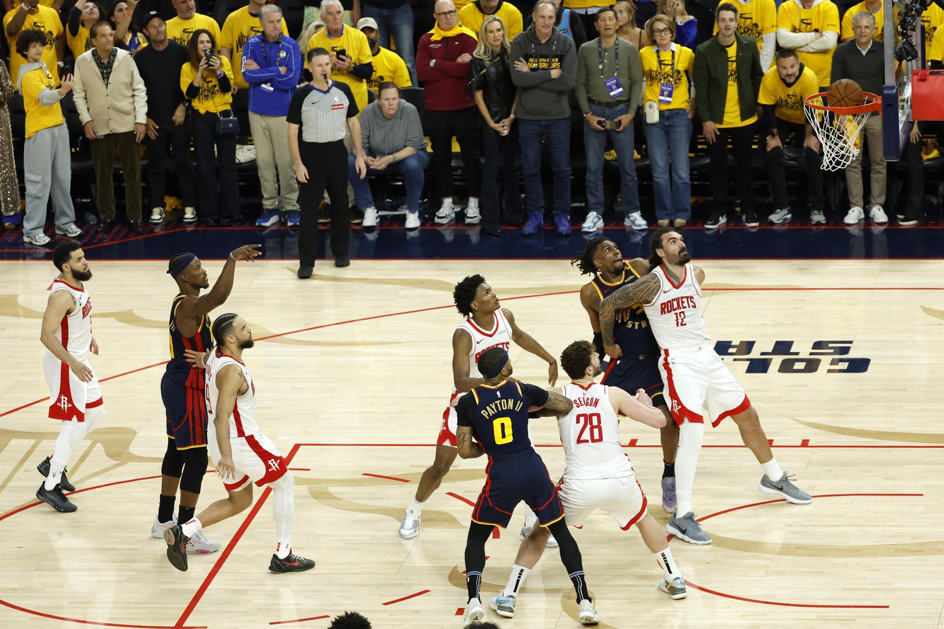 El delantero de los Golden State Warriors, Jimmy Butler III (2-I) lanza un tiro libre contra los Houston Rockets con cuatro segundos restantes en el cuarto cuarto del partido. EFE/EPA/JOHN G. MABANGLO FUERA DE SHUTTERSTOCK