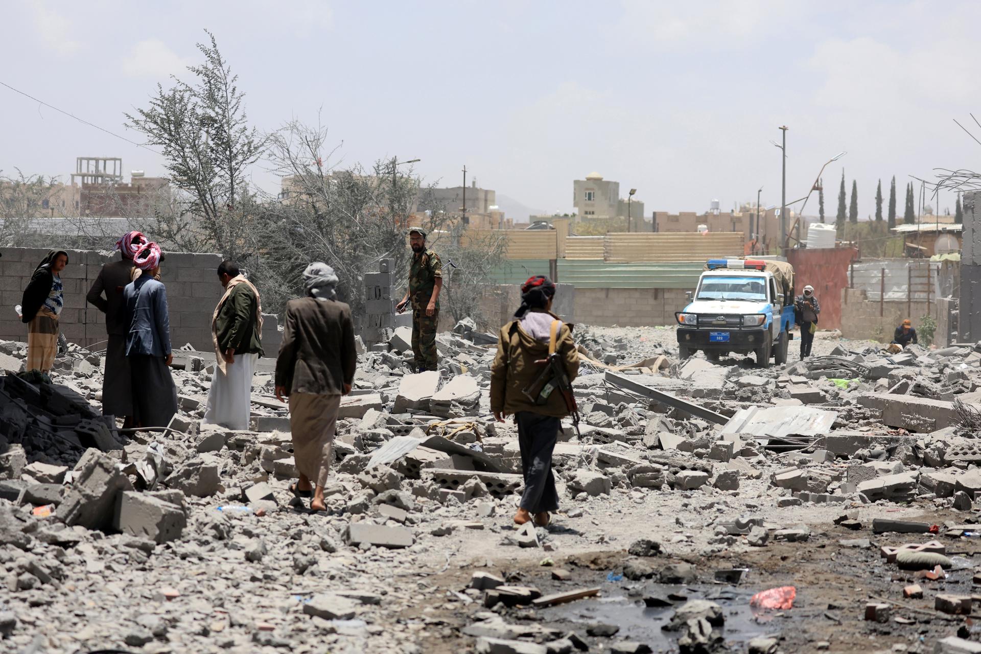 Yemeníes caminan entre los escombros mientras inspecciona un área dañada tras los ataques aéreos de EE. UU. que tuvieron como objetivo un vecindario en Sana'a, Yemen, 27 de abril de 2025. 
EFE/EPA/YAHYA ARHAB