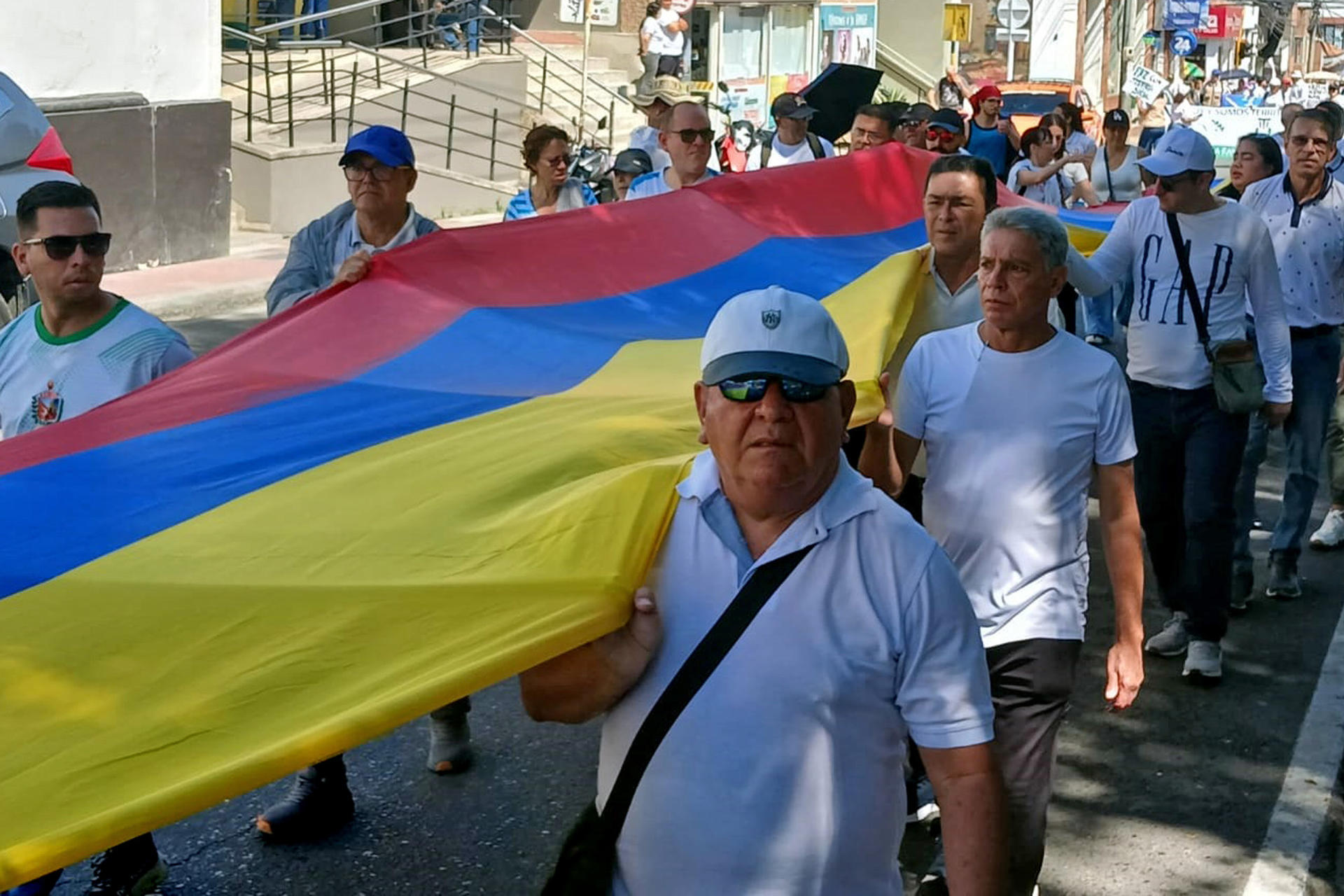 Foto de archivo que muestra a personas sosteniendo una bandera de Colombia durante una manifestación para exigir el respeto a la vida y la paz. EFE/ Ana Inés Vega