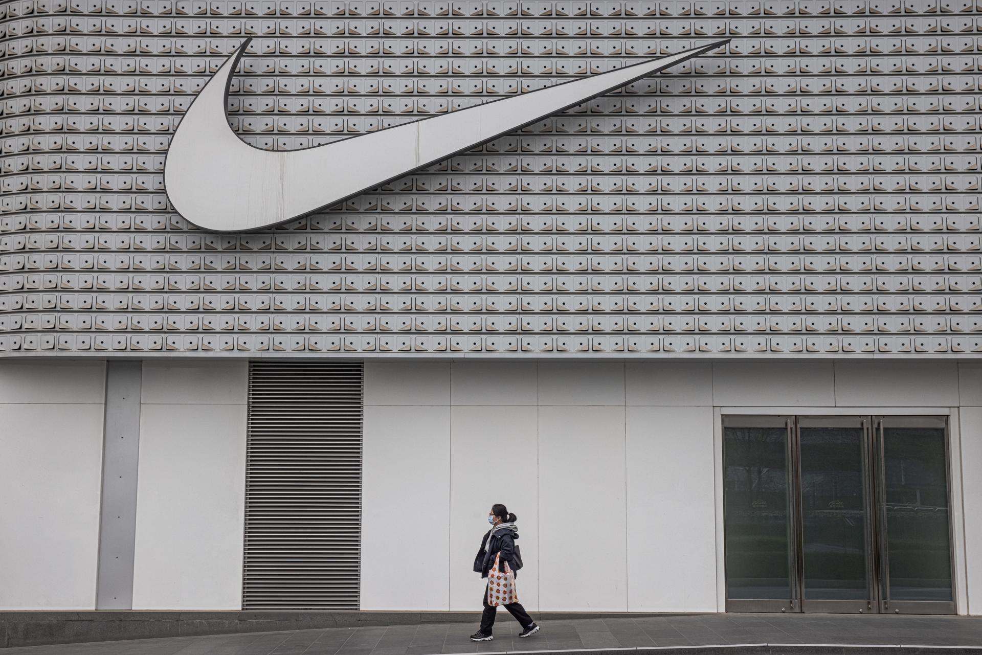 Fotografía de archivo que muestra a una mujer pasando frente a una tienda Nike en Pekín, China. EFE/EPA/ROMAN PILIPEY