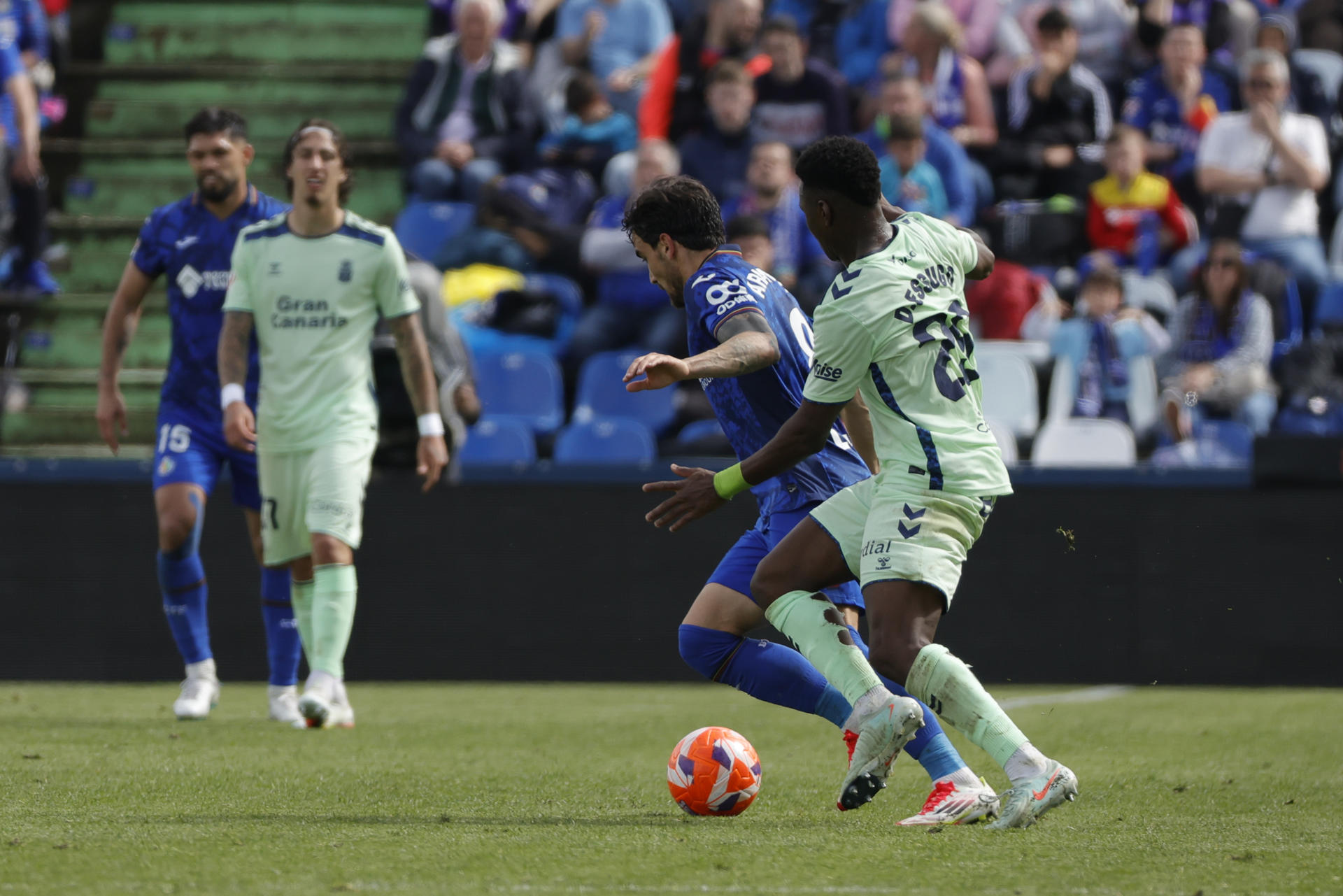 El centrocampista del Getafe Mauro Arambarri (2d) disputa un balón con el centrocampista de Las Palmas Dário Essugo (d) durante el encuentro de la jornada 31 de LaLiga EA Sports entre Getafe CF y UD Las Palmas, este sábado en el Coliseum de Getafe, en Madrid. EFE/ Zipi
