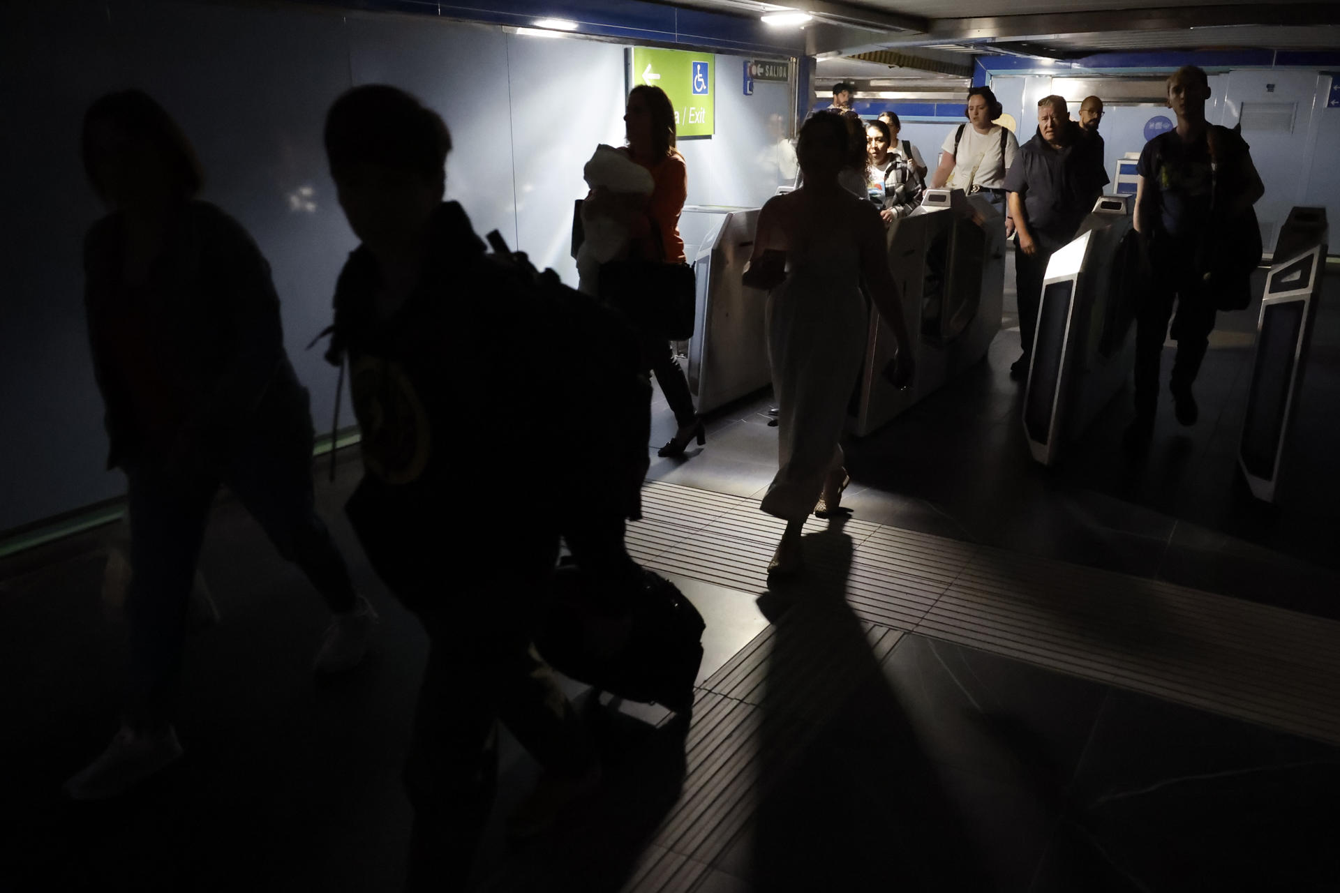 Usuarios del metro de Madrid abandonan una de las estaciones del suburbano tras registrarse un apagón a nivel peninsular este lunes. EFE/Mariscal