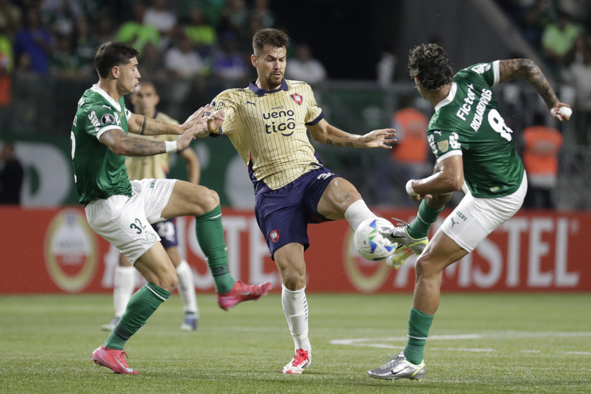 Richard Ríos (d) de Palmeiras disputa un balón con Gastón Giménez (c) de Cerro en un partido de la fase de grupos de la Copa Libertadores. EFE/ Sebastião Moreira