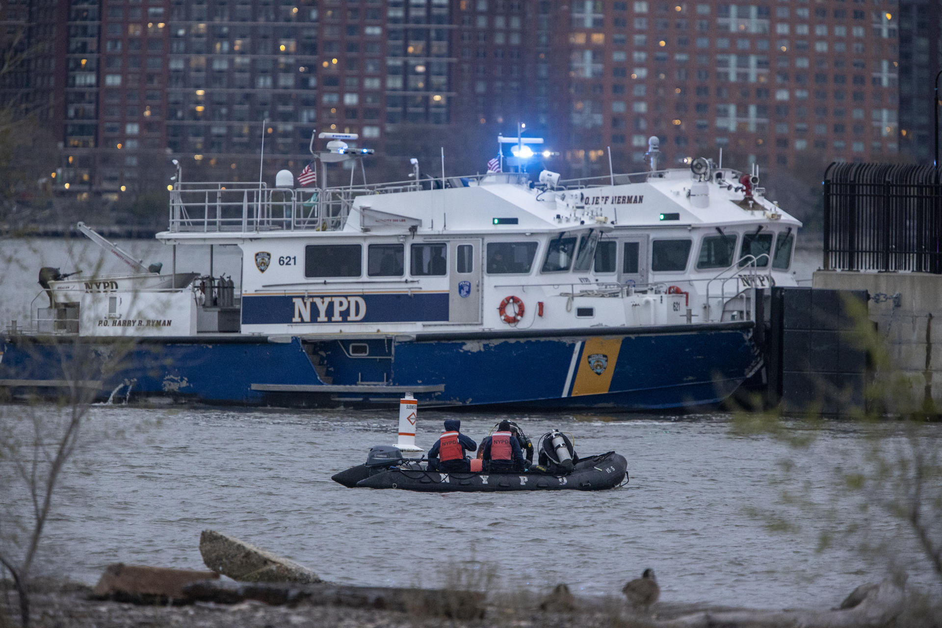 Personal de organismos de emergencia participan en las labores de rescate tras el accidente de un helicóptero en el Río Hudson, en Nueva York (Estados Unidos). EFE/ Angel Colmenares