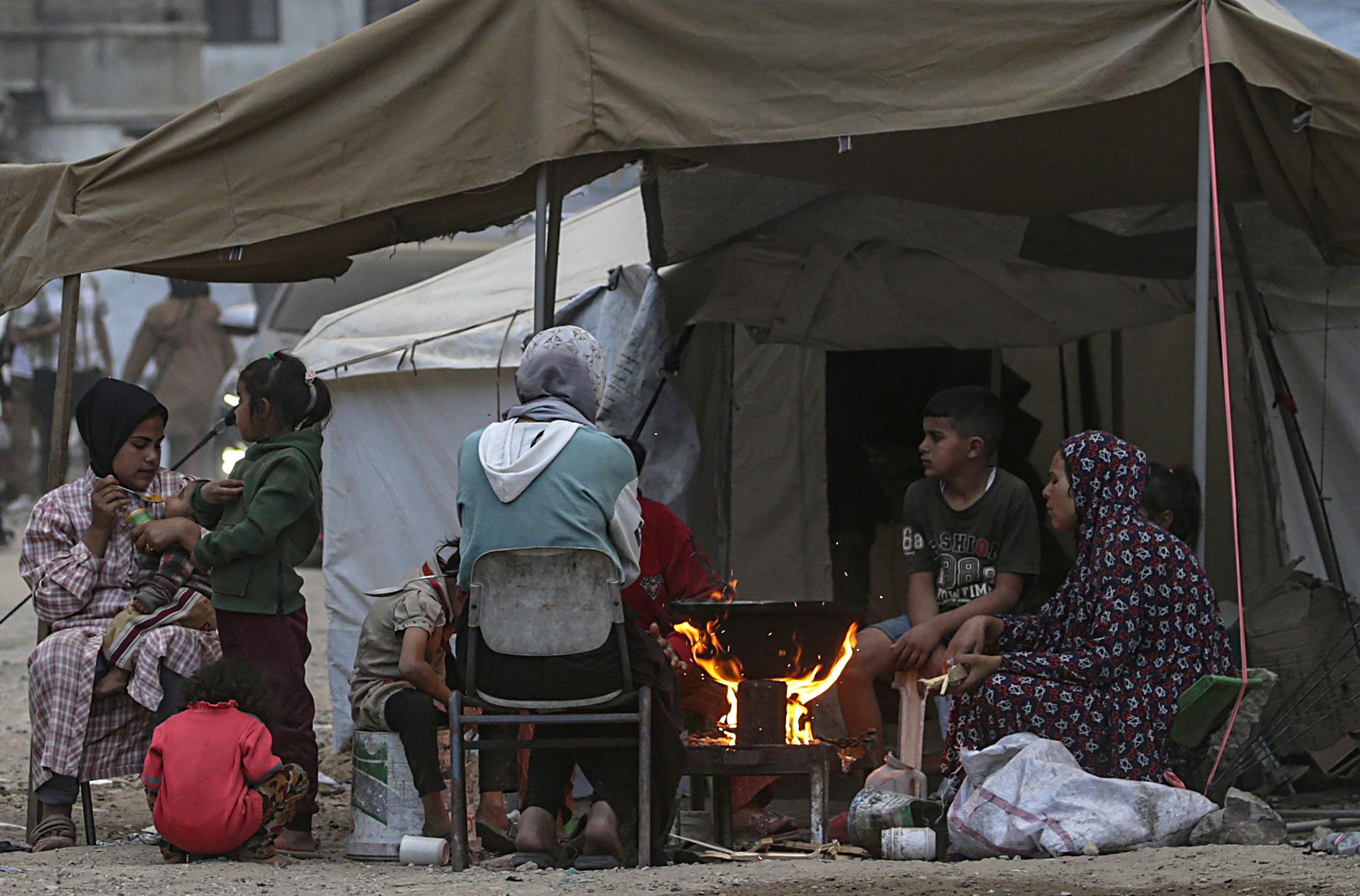 Miembros de una familia palestina desplazada internamente preparan comida sobre un fuego fuera de su tienda después de huir del norte de Gaza tras una orden de evacuación del ejército israelí, en la Ciudad de Gaza, Franja de Gaza, 01 de abril de 2025. 
EFE/EPA/MOHAMMED SABER