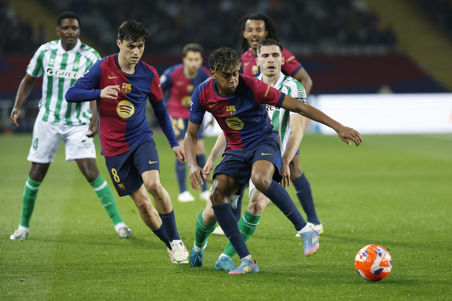 El delantero del FC Barcelona, Lamine Yamal (d), con el balón durante el encuentro correspondiente a la jornada 30 de Laliga EA Sports que disputan hoy sábado FC Barcelona y Betis en el Estadio Olímpico Lluis Companys de Barcelona. EFE / Toni Albir