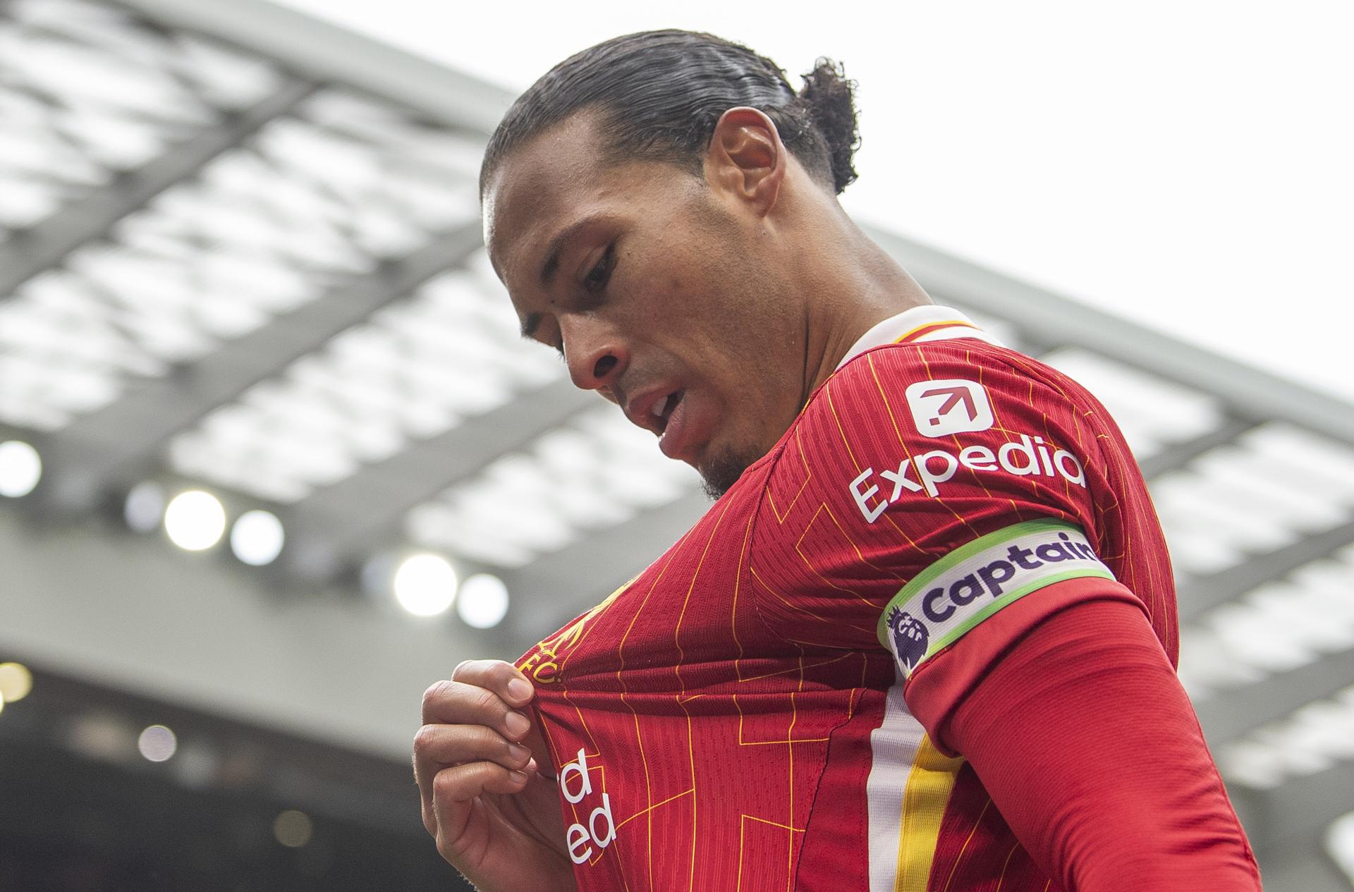 El neerlandés Virgil van Dijk, capitán del Liverpool, besa el escudo de su camiseta después de anotar el gol de la victoria en el partido de la Premier League ante el West Ham, el 13 de abril. EFE/EPA/PETER POWELL