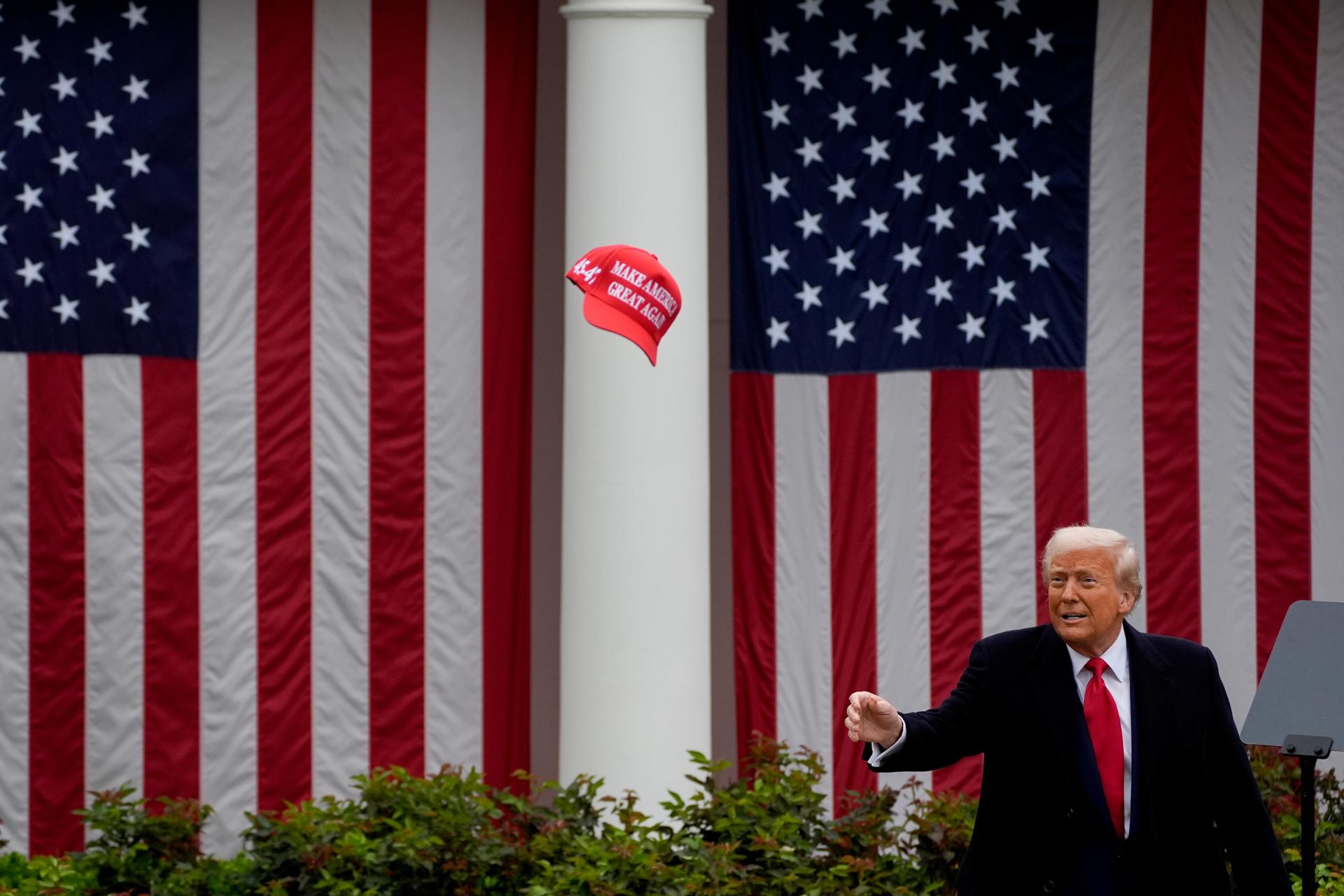 El presidente de Estados Unidos, Donald Trump, al lanzar una gorra durante el acto de anuncio de "aranceles recíprocos" a muchos países con los que su país sostiene relaciones comerciales, este miércoles, 2 de abril, en la Rosaleda de la Casa Blanca, en Washington DC (EE.UU.). EFE/Kent Nishimura/Pool