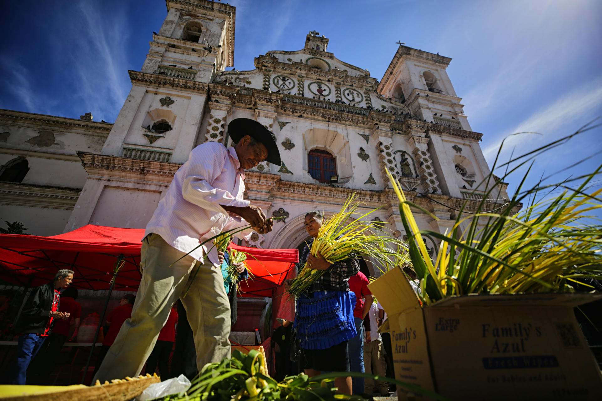 Personas llegan para participar en la misa de Domingo de Ramos en la Iglesia Los Dolores este domingo en Tegucigalpa (Honduras). EFE/Gustavo Amador