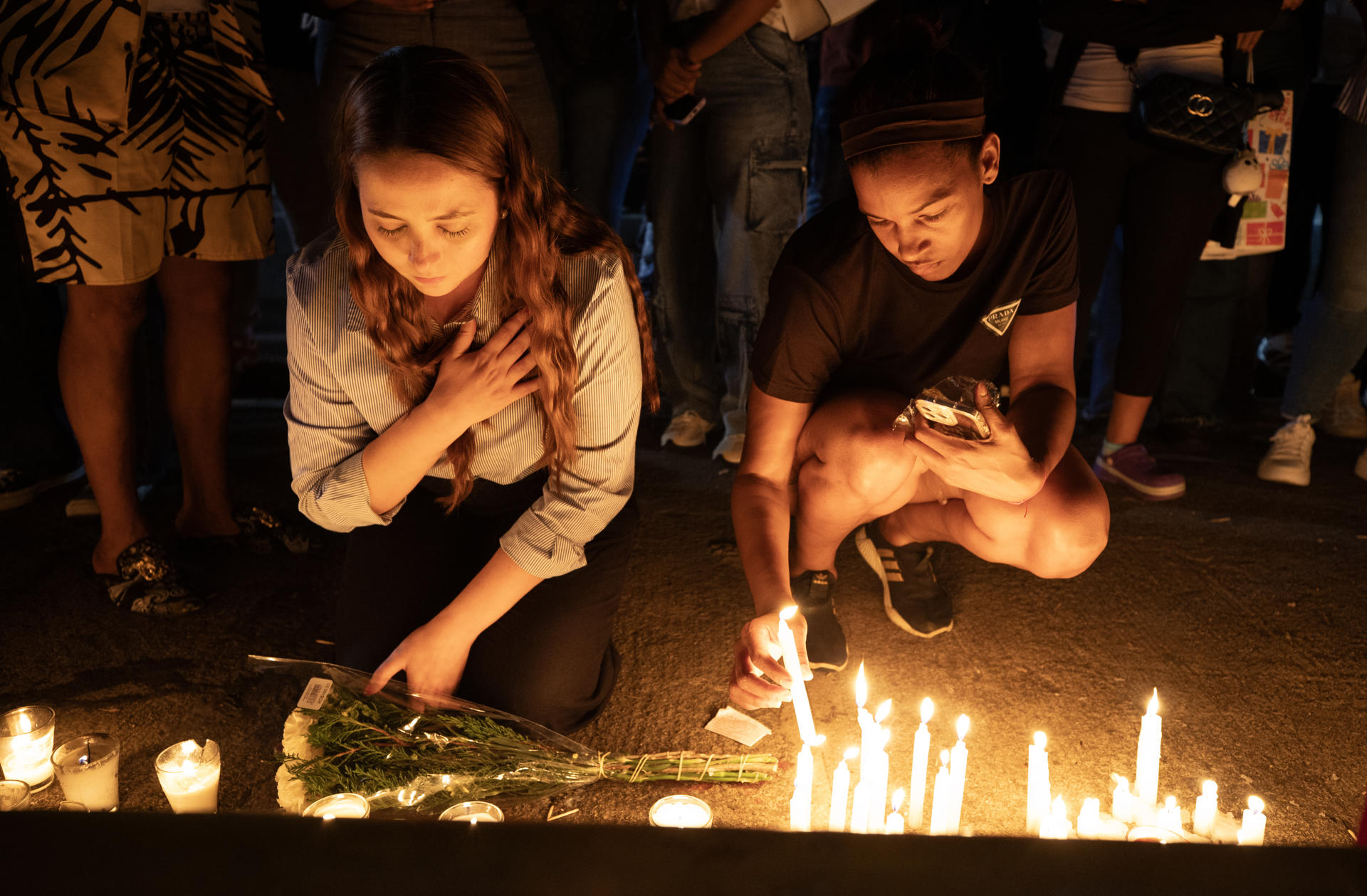 Un par de mujeres participaron este viernes, 11 de abril, en una velatón en memoria de las más de 220 personas fallecidas por el colapso del techo de la discoteca Jet Set, la madrugada de pasado martes, en Santo Domingo (República Dominicana). EFE/Orlando Barría