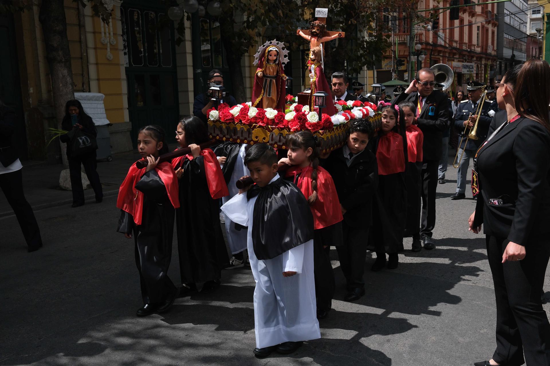 Niños sostienen una imagen de la crucifixión este Domingo de Ramos, en La Paz (Bolivia). EFE/ Luis Gandarillas