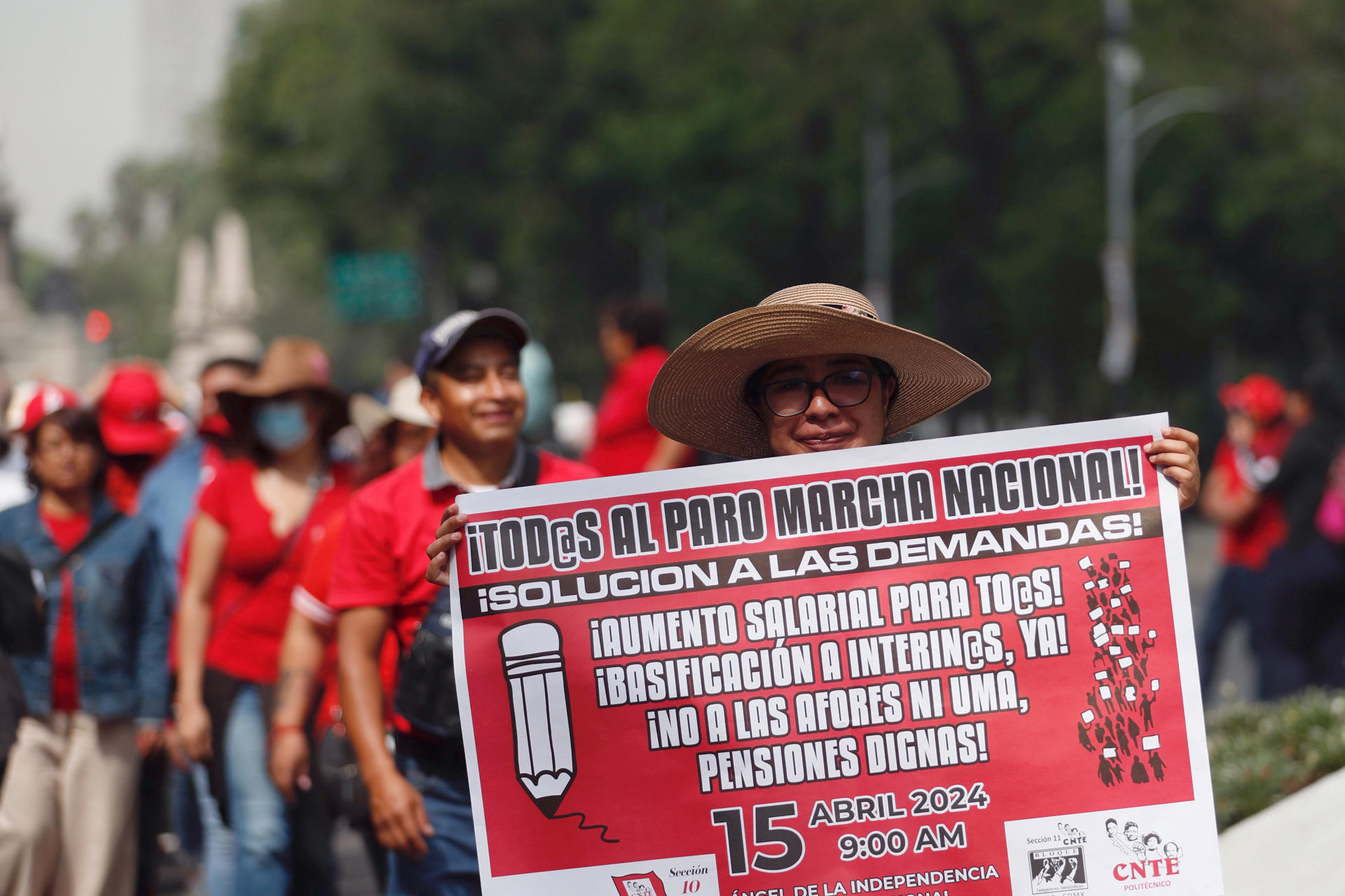 Fotografía de archivo del 15 de abril de 2024 de una integrante de la Coordinadora Nacional de Trabajadores de la Educación (CNTE) sosteniendo un cartel durante una manifestación en Ciudad de México (México). EFE/ Sáshenka Gutiérrez