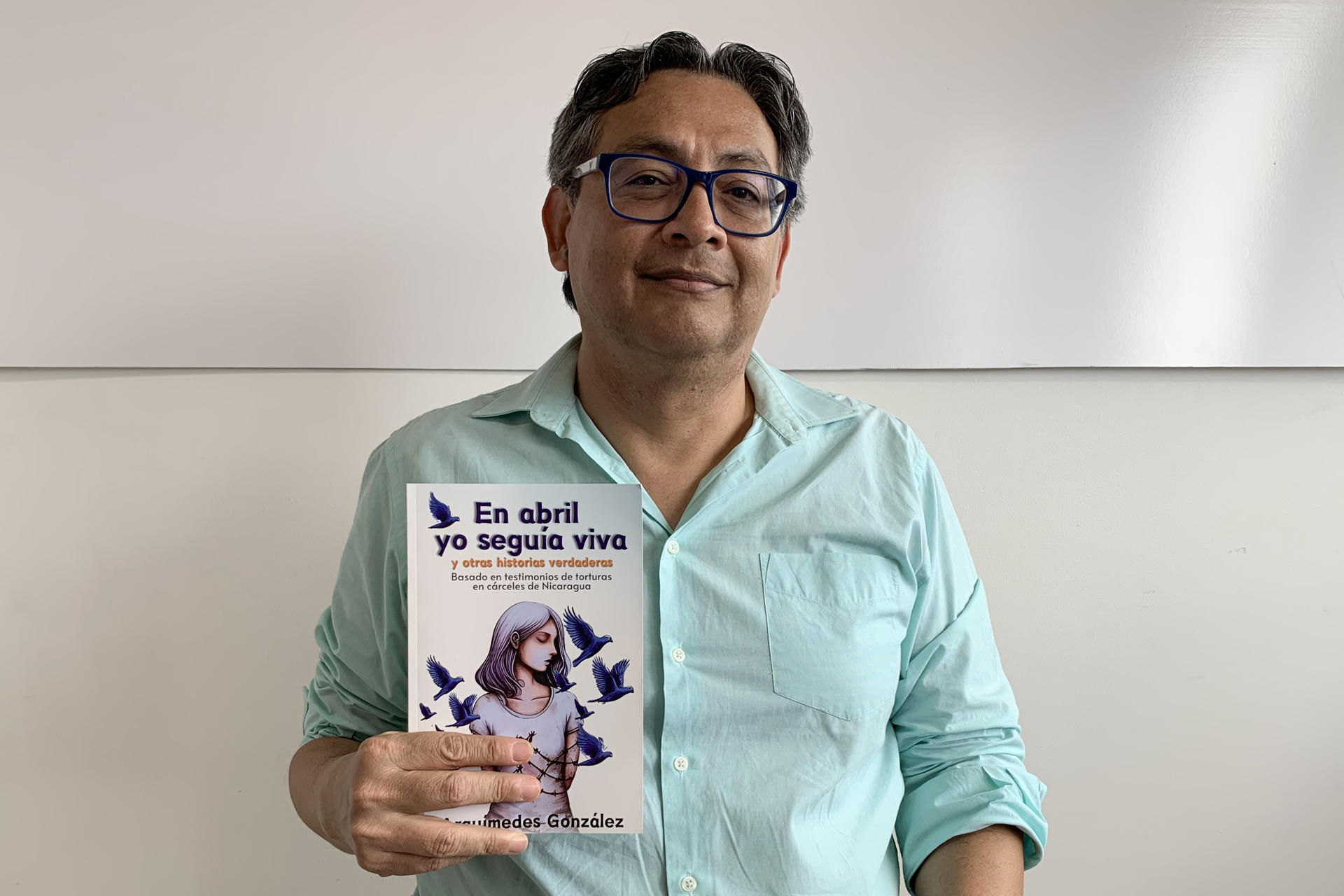 Fotografía tomada el pasado 31 de marzo en la que aparece el escritor nicaragüense Arquímedes González, al posar para EFE con un ejemplar de su más reciente libro 'En abril yo seguía viva', en San José (Costa Rica). EFE/Douglas Marín