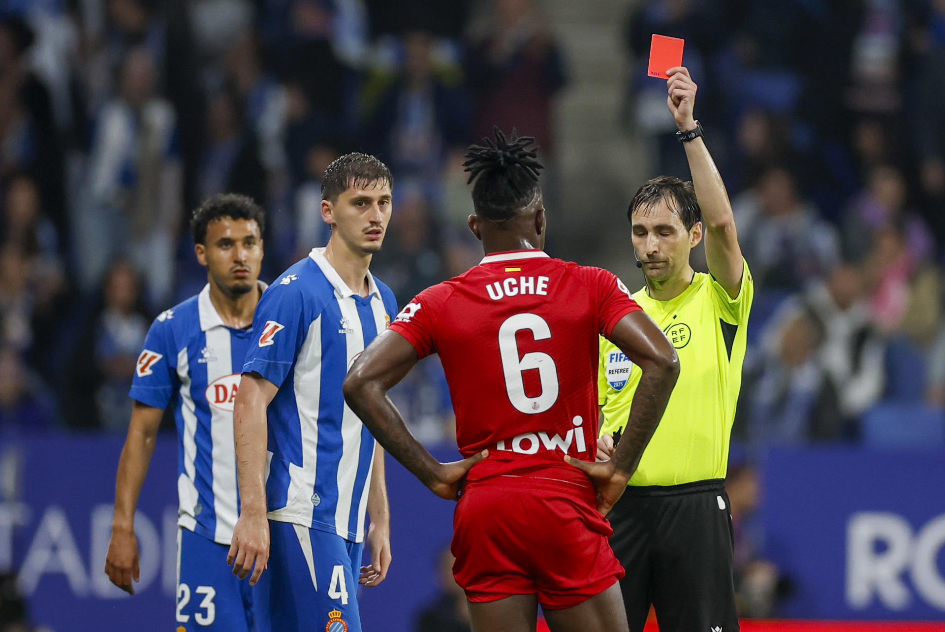 El colegiado De Burgos Bengoechea muestra tarjeta roja al nigeriano del Getafe, Christantus Uche, durante el partido de la jornada 32 de LaLiga EA Sports, entre el RCD Espanyol y el Getafe, en el RCDE Stadium de Barcelona. EFE/ Alberto Estévez