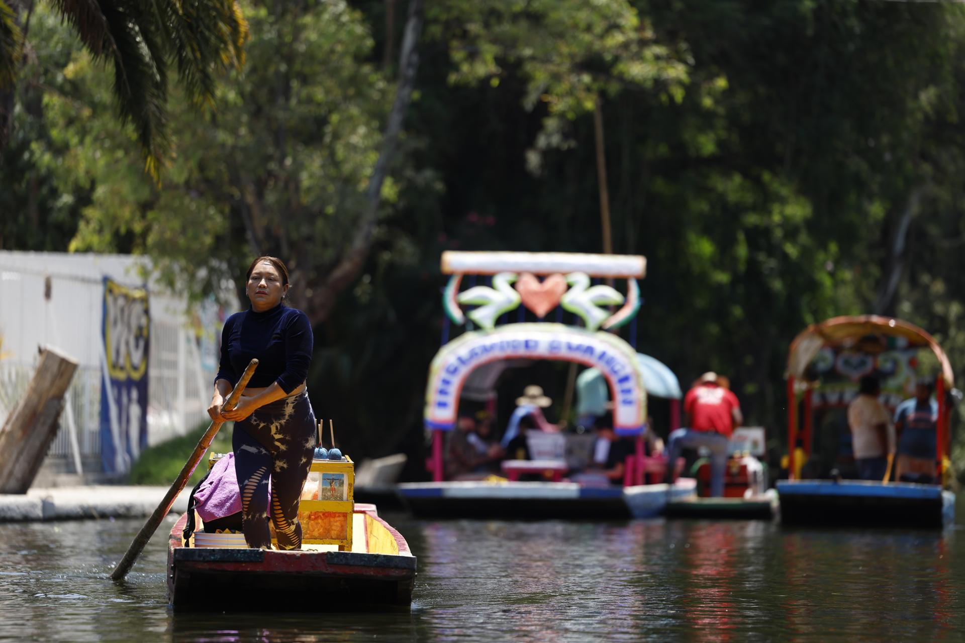 Una mujer comerciantes vende sus productos en una canoa del embarcadero de Xochimilco, durante la presentación de la canoa alegórica este miércoles, en Ciudad de México (México). EFE/ Sáshenka Gutiérrez