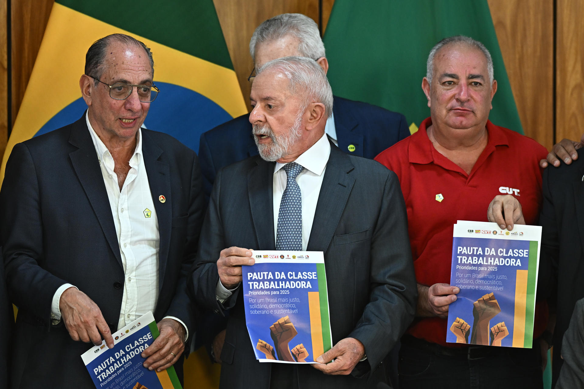 El presidente de Brasil, Luiz Inácio Lula da Silva, sostiene una lista de requerimientos de la clase trabajadora entregada por los representantes de las centrales sindicales durante una reunión este martes, en el Palacio de Planalto en Brasilia (Brasil). EFE/ Andre Borges