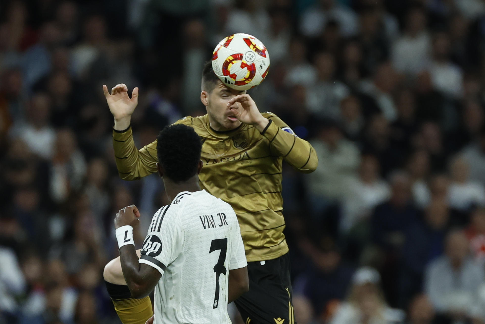 El defensa de la Real Sociedad Igor Zubeldia (detrás) despeja ante el delantero brasileño del Real Madrid, Vinicius Junior durante el partido de vuelta de las semifinales de la Copa del Rey. EFE/JuanJo Martín