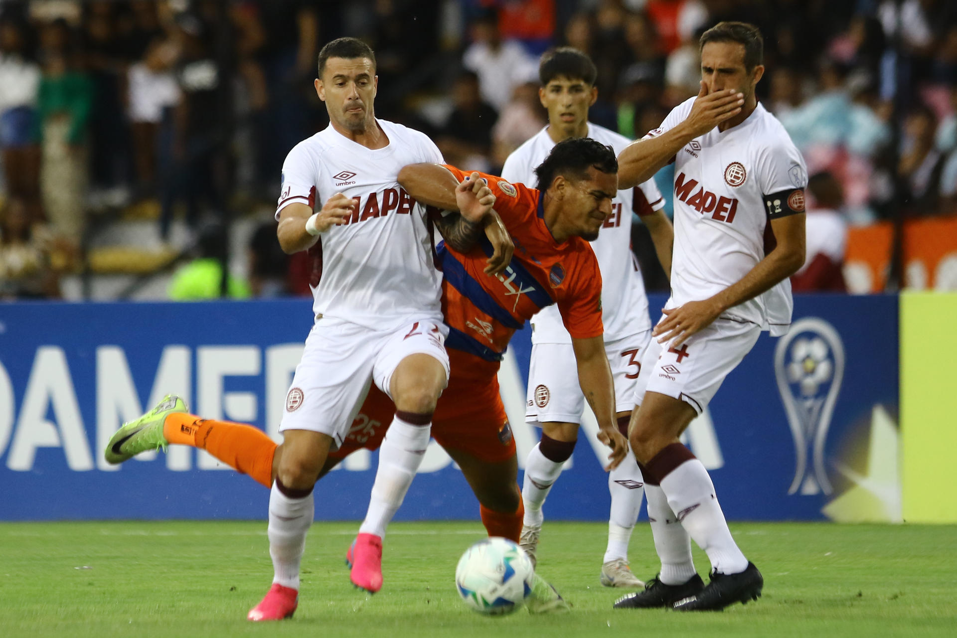 Junior Paredes (c) de Puerto Cabello disputa un balón con Ramiro Carrera (i) de Lanús en un partido de la fase de grupos de la Copa Sudamericana . EFE/ Juan Carlos Hernández