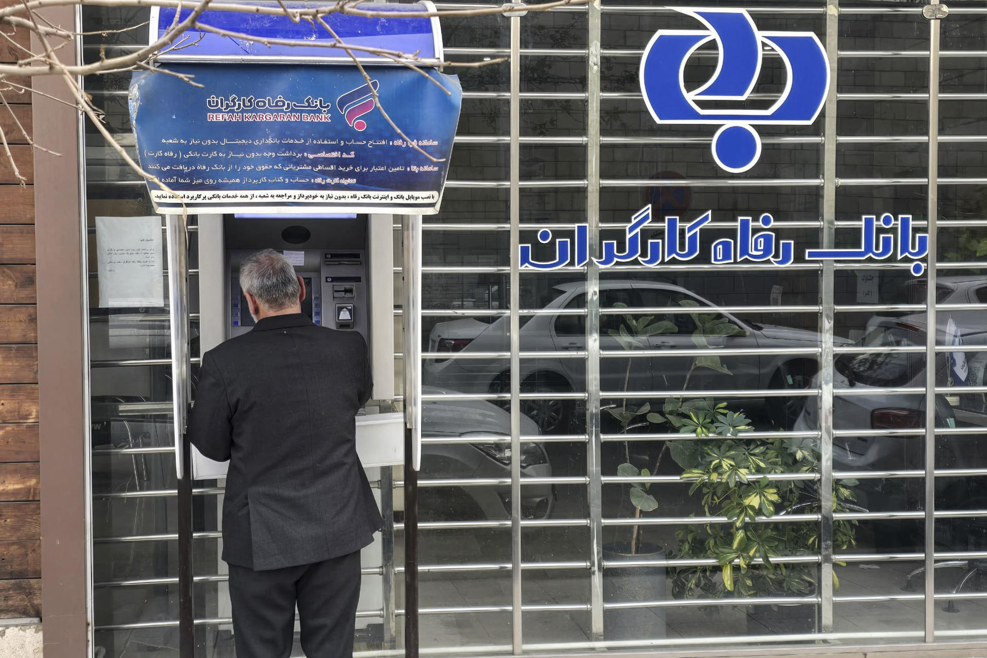 Un hombre saca dinero del cajero automático de un banco en el norte de Teherán. EFE/Aydin Shayegan