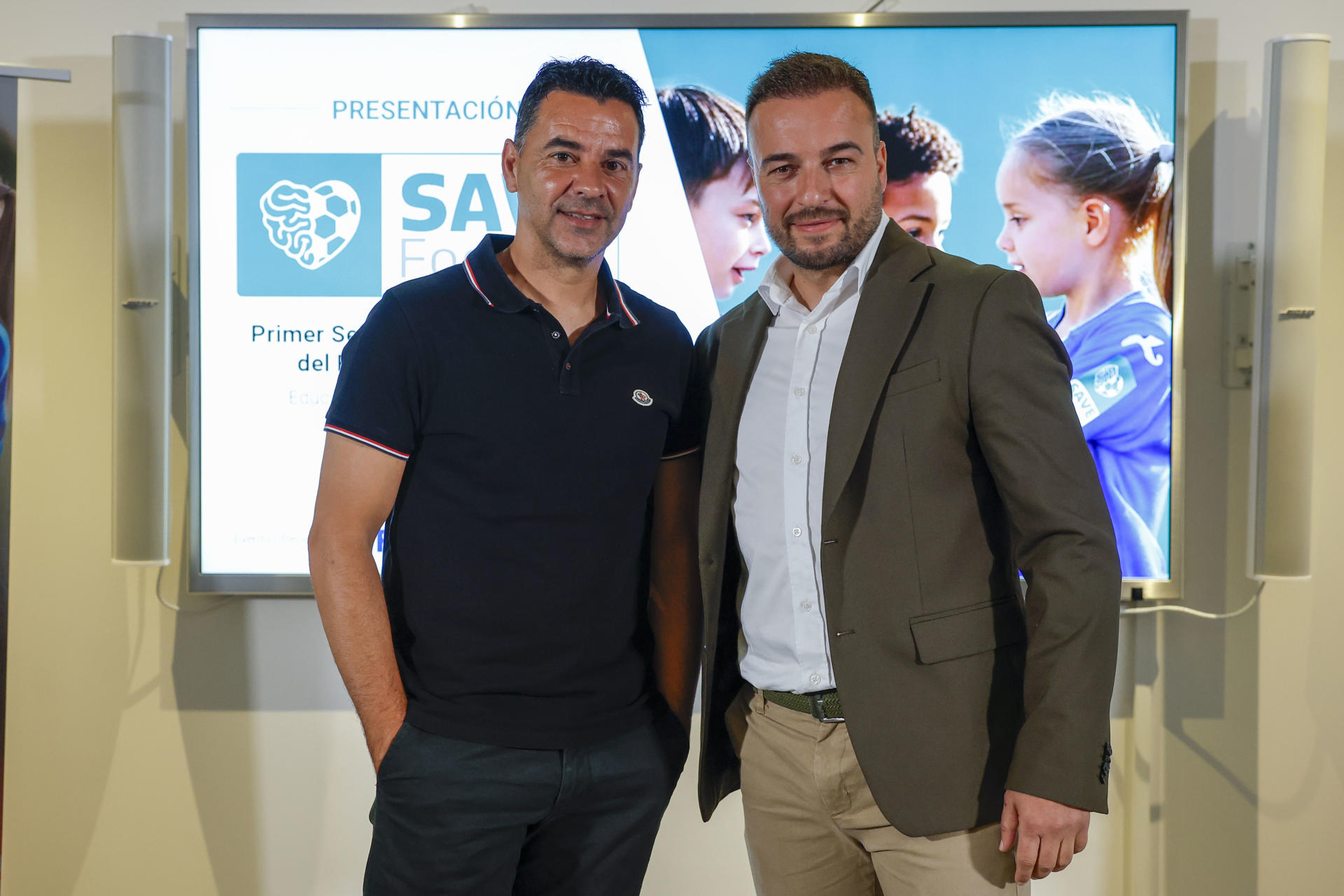 El entrenador del Girona, Michel (i) y el consejero delegado de Evie Fútbol,Rubén Godoy (d) durante la presentación de la iniciativa ‘Save Football’, un innovador sello de calidad que busca erradicar la violencia, el racismo y otras conductas perjudiciales en el fútbol base, a la par que promueve valores educativos e inyecta calidad humana en los clubes deportivos y que fue presentado este viernes en la sede central de la Agencia EFE. EFE/JJ Guillén