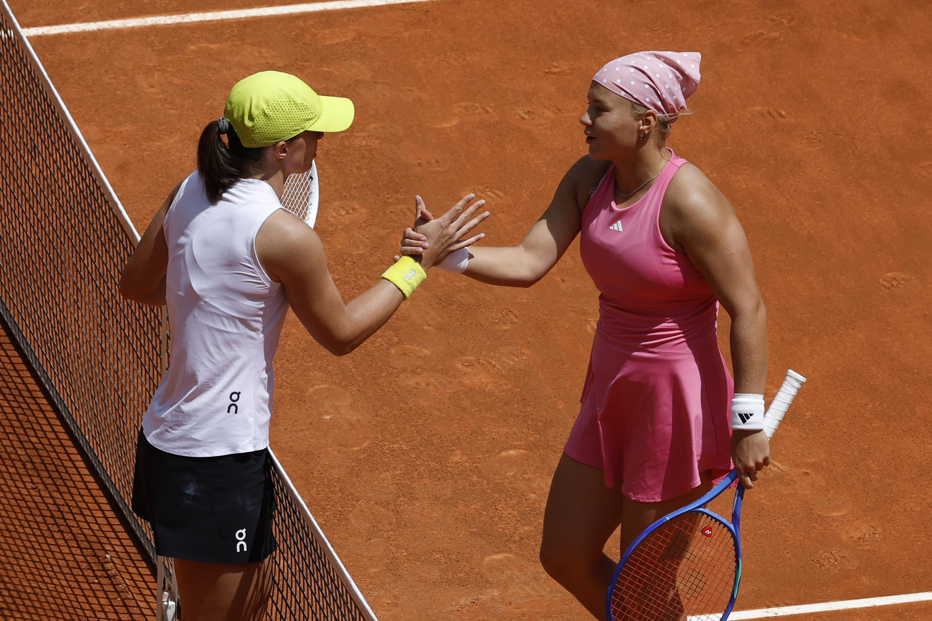 La tenista polaca Iga Swiatek (I) es felicitada por Diana Shnaider, de Rusia, a quien derrotó en el partido de octavos de final del Mutua Madrid Open. EFE/ Chema Moya