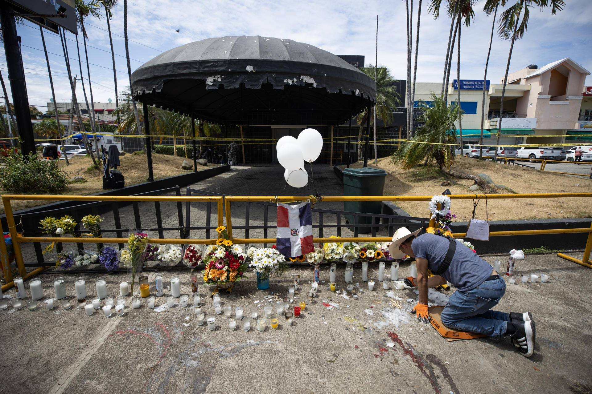 Un hombre enciende velas en la entrada de la discoteca Jet Set este viernes, en Santo Domingo (República Dominicana). EFE/ Orlando Barría