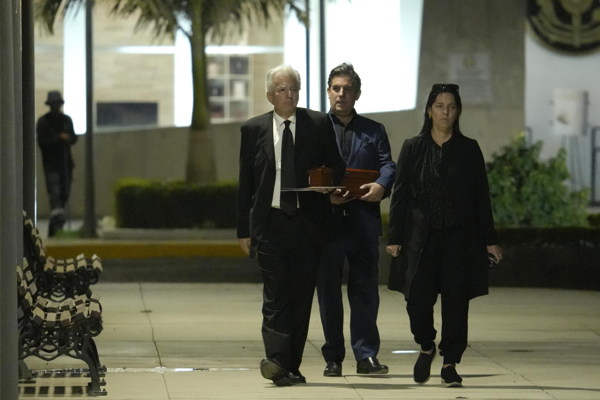 (De i a d) Álvaro Vargas Llosa, Gonzalo Vargas Llosa y Morgana Vargas Llosa, hijos del escritor peruano Mario Vargas Llosa, al caminar con dos urnas que portan los restos de su padre, en las afueras del Centro Funerario y Crematorio del Ejército de Chorrillos, en Lima (Perú). EFE/John Reyes Mejía