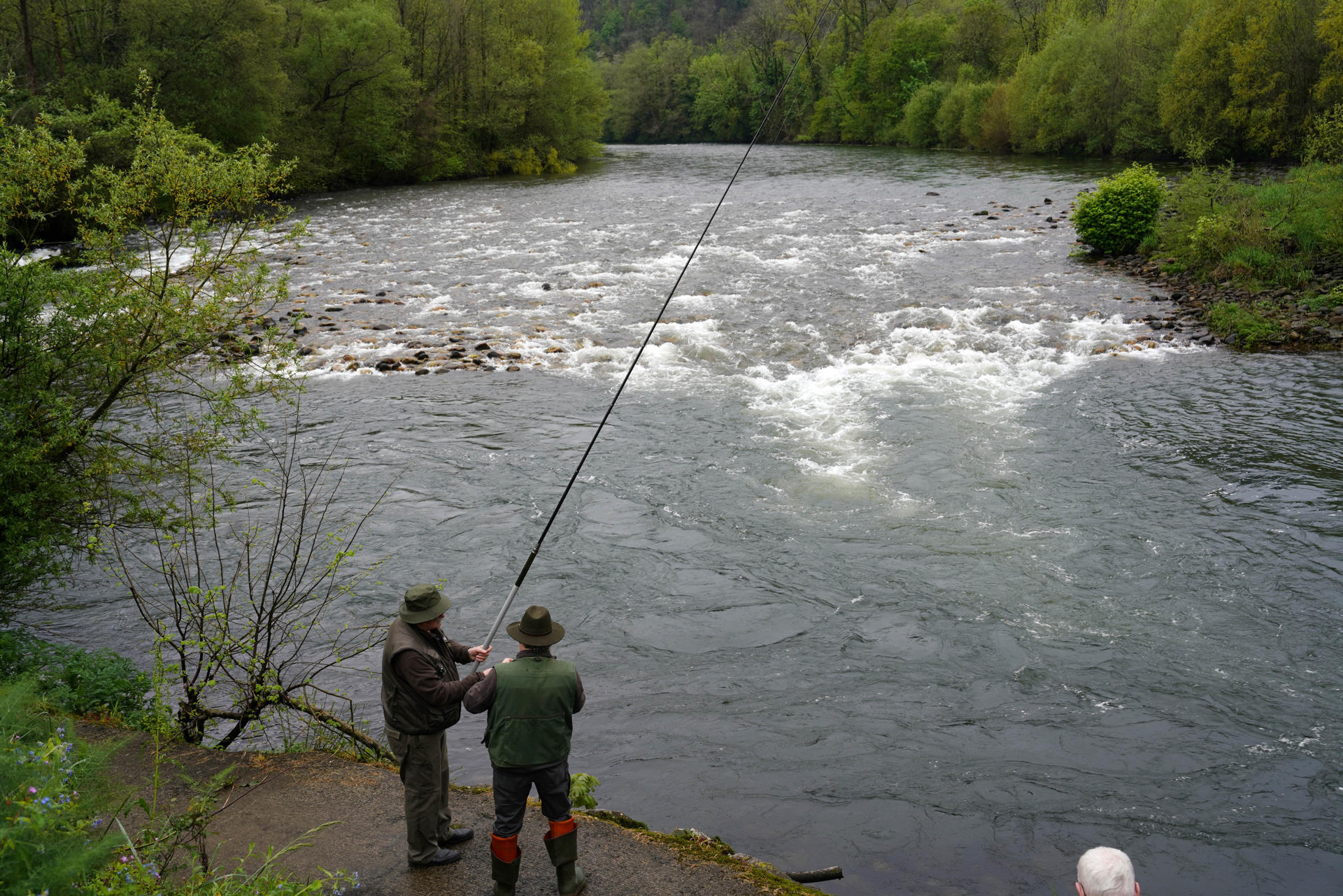 CORNELLANA, 13/04/2025.- Cientos de pescadores tratan este domingo de hacerse con el preciado 'campanu', el primer salmón que se captura en Asturias al inicio de cada temporada y que el pasado año fue un ejemplar de 8,2 kilos y 92 centímetros de longitud por el que se pagaron 19.300 euros, una cifra nunca alcanzada hasta ahora en la tradicional subasta. EFE/Paco Paredes