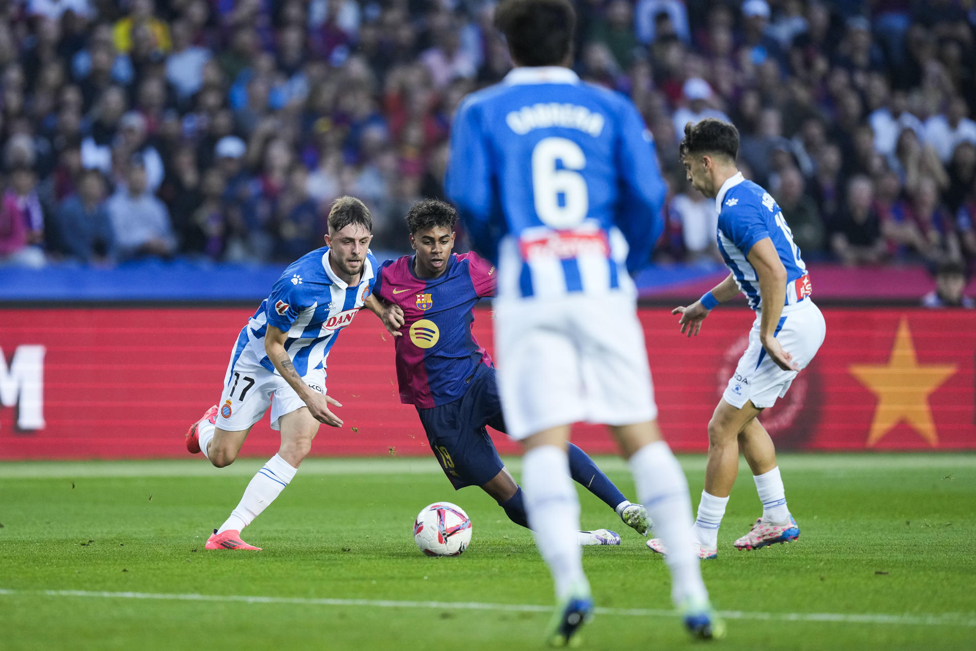El extremo del FC Barcelona Lamine Yamal (2i) y delantero del Espanyol Jofre Carreras (i), en acción durante el partido de LaLiga que enfrentó al FC Barcelona contra el Espanyol este domingo en el Camp Nou en Barcelona. EFE/ Enric Fontcuberta