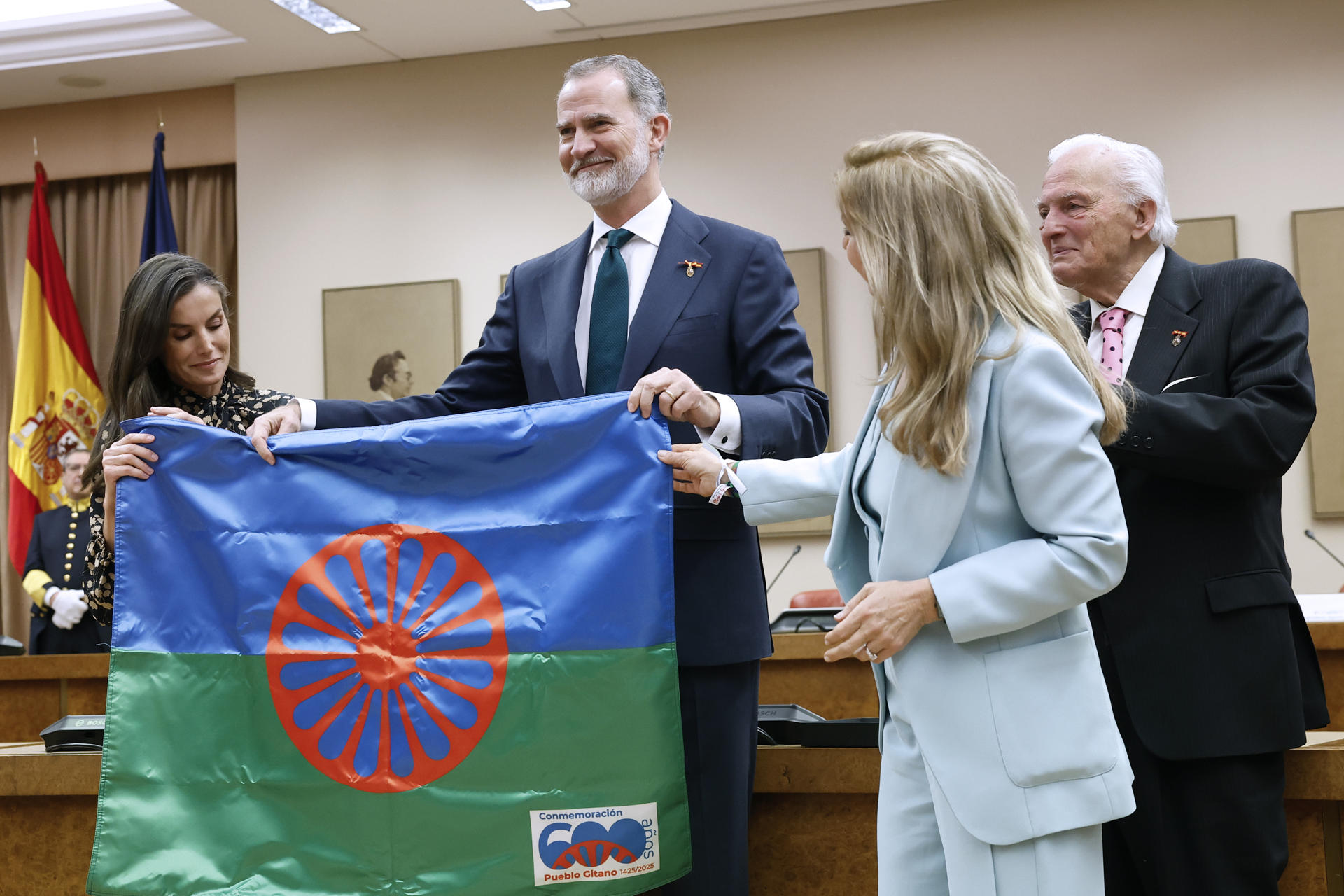 El rey Felipe VI y la reina Letizia, acompañados por la presidenta del Consejo Estatal del Pueblo Gitano, Carmen Santiago (2d), y por el al presidente de la Unión Romaní, Juan de Dios Ramírez Heredia (d), reciben una bandera gitana tras presidir el acto de conmemoración del Día Internacional del Pueblo Gitano este martes en el Congreso de los Diputados en Madrid. EFE/ Chema Moya