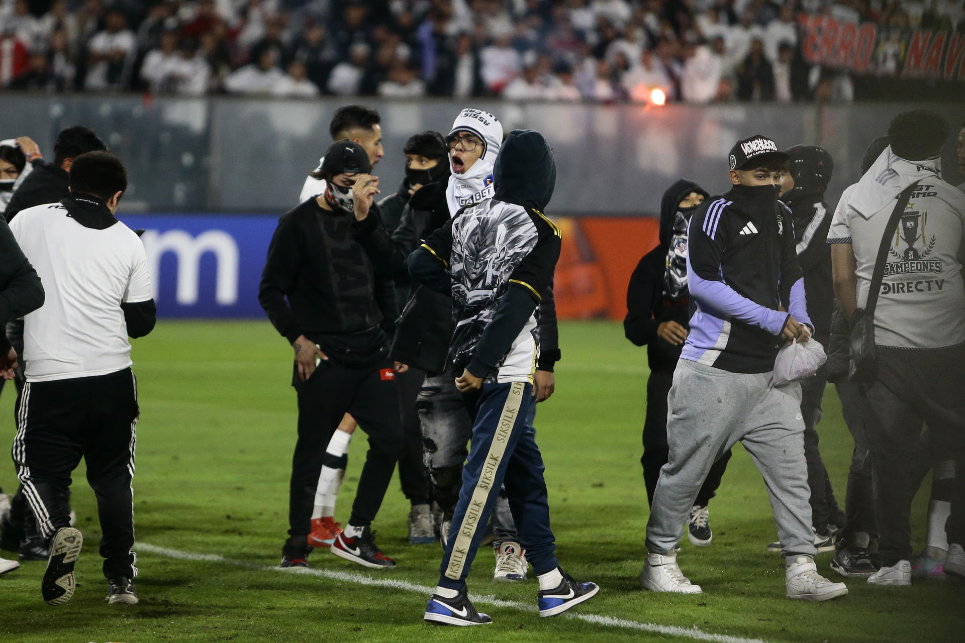 Hinchas de Colo Colo invadieron el campo tras la muerte de dos aficionados asfixiados por una avalancha luego de una carga policial en Libertadores.. EFE/ Osvaldo Villarroel
