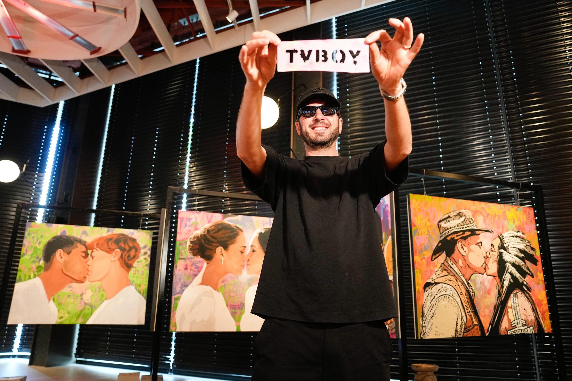 La sede de Casa Seat Barcelona acoge desde este lunes la exposición ‘Besos Prohibidos’ del artista urbano TVBoy, una selección de osculos "inesperados" entre figuras públicas, como Rosalía y Bad Gyal, Meghan Markle y Kate Middleton, o Pablo Motos y David Broncano. EFE/Enric Fontcuberta