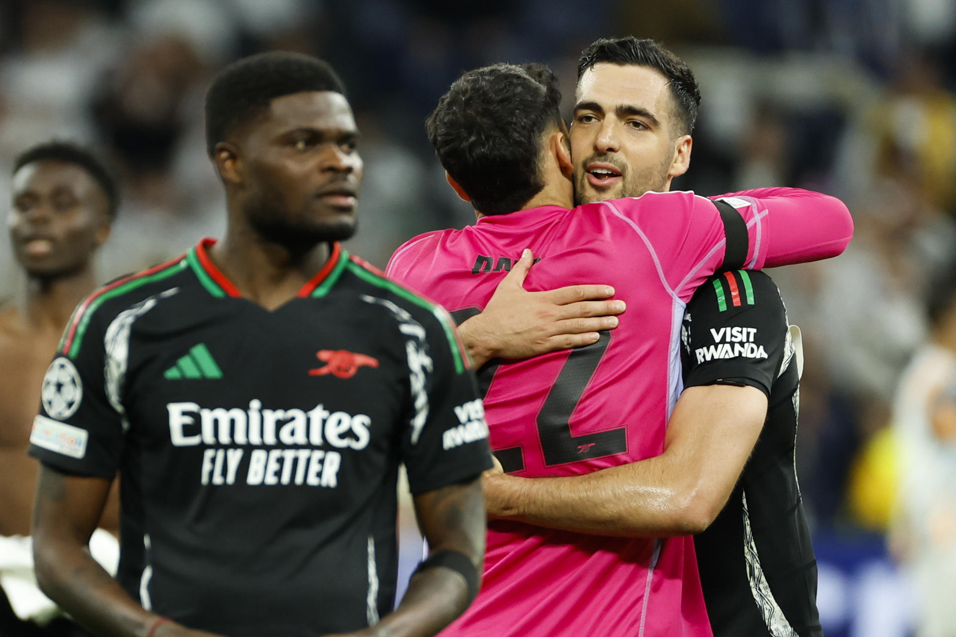 Los jugadores españoles del Arsenal, Mikel Merino (d) y David Raya, celebran la victoria tras el partido de vuelta de cuartos de final de la Liga de Campeones que Real Madrid y Arsenal jugaron en el estadio Santiago Bernabéu. EFE/Mariscal