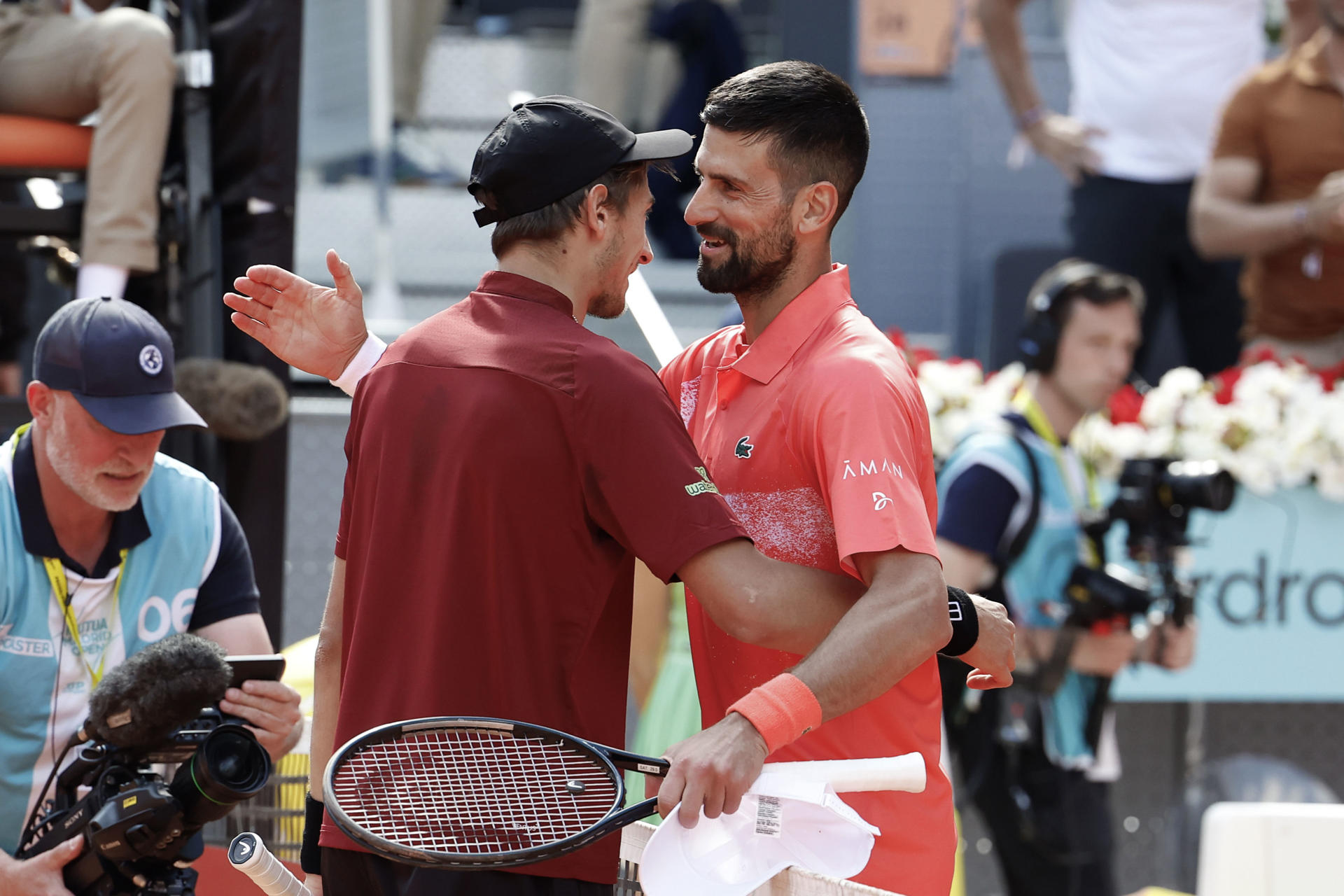 El tenista italiano Matteo Arnaldi (i) saluda al serbio Novak Djokovic tras el partido individual masculino de segunda ronda del Masters 1000 de Madrid que disputaron en la Caja Mágica en la capital de España. EFE/ Chema Moya