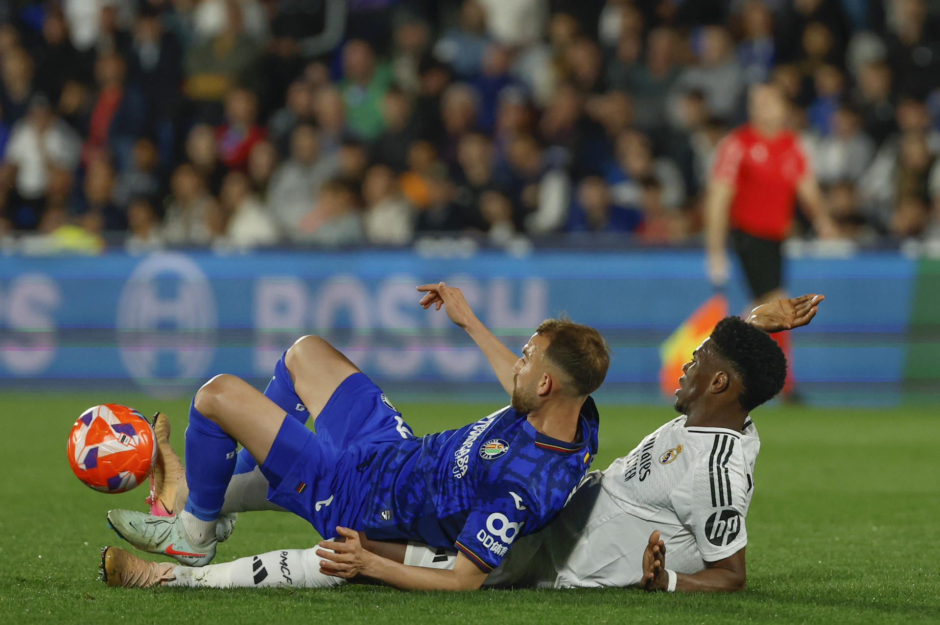 El delantero del Getafe, Borja Mayoral (i), cae ante el centrocampista francés del Real Madrid, Aurelien Tchouameni, durante el partido de la jornada 33 de LaLiga que Getafe CF y Real Madrid disputaron en el Coliseum de Getafe. EFE/Mariscal