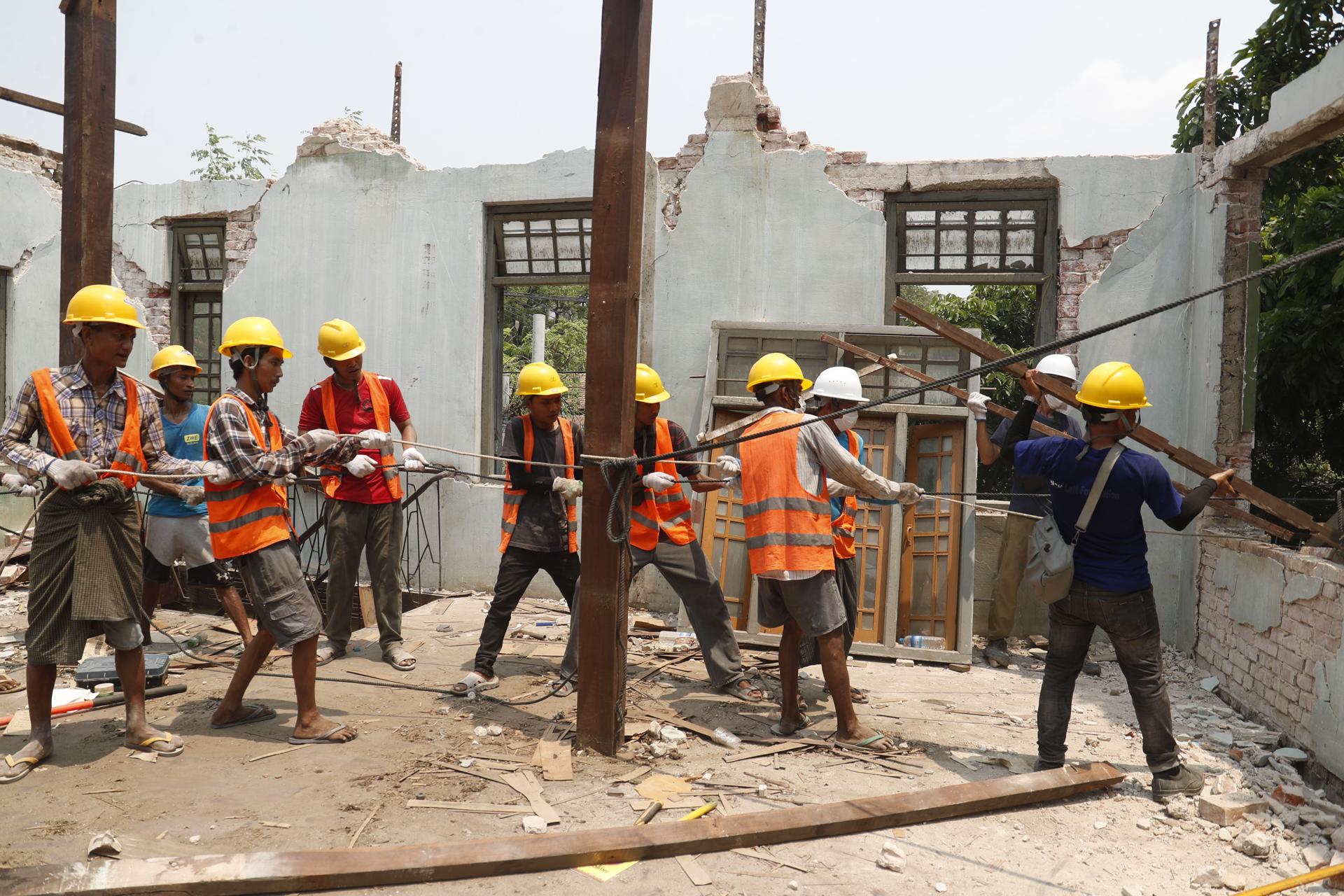 SAGAING (Myanmar), 27/04/2025.- Volunteers demolish a collapsed house in Sagaing, Myanmar, 27 April 2025. A 7.7-magnitude earthquake struck the country on 28 March, severely impacting six regions and states, resulting in over 3,600 deaths, thousands injured, and 145 still missing, according to the Myanmar government. (Terremoto/sismo, Birmania) EFE/EPA/NYEIN CHAN NAING