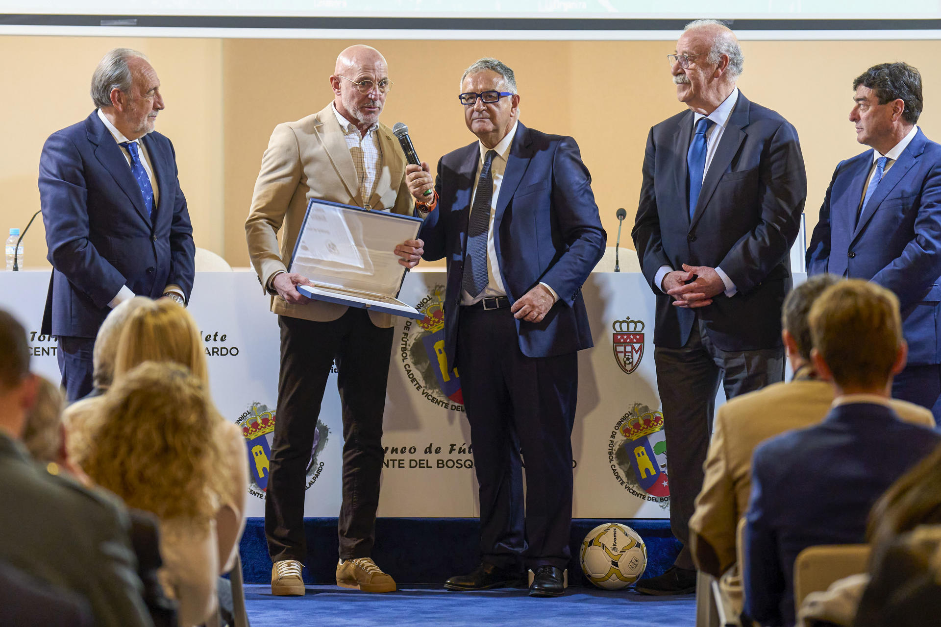 Luis de la Fuente (2i), seleccionador español de fútbol, se refirió a los resultados de ida de las dos eliminatorias de cuartos de final de la Liga de Campeones jugadas por el Real Madrid y el Barcelona ante el Arsenal y el Borussia Dortmund respectivamente y consideró que, aunque el conjunto blanco perdió por 3-0 en la ida, no da su cruce por decidido. "Está todo muy abierto, conocemos cómo se las gasta el Real Madrid en casa y no doy esa eliminatoria por decidida. El Barcelona hizo un fantástico partido", declaró tras recoger un premio en la presentación de la IX edición del Torneo de Fútbol Cadete Vicente del Bosque (2d), de Alalpardo.-EFE/Torneovicentedelbosque***SOLO USO EDITORIAL/SOLO DISPONIBLE PARA ILUSTRAR LA NOTICIA QUE ACOMPAÑA (CRÉDITO OBLIGATORIO)***