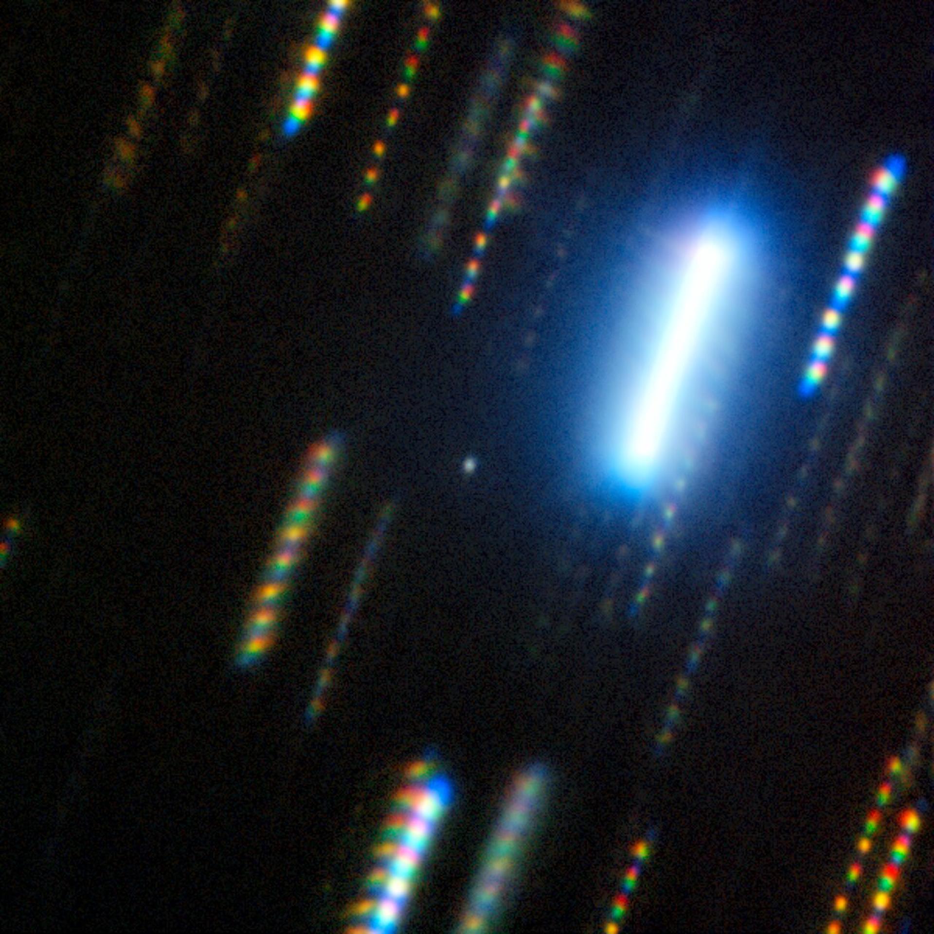 Imagen compuesta del asteroide 2024 YR4 capturada con el telescopio Gemini Sur (Chile) en febrero de 2025. El asteroide es el punto nebuloso en el centro de la imagen, que está rodeado de coloridas estelas de estrellas, las cuales muestran el paso del tiempo y el movimiento del cielo nocturno en una imagen fija. EFE/International Gemini Observatory/NOIRLab/NSF/AURA/M. Zamani