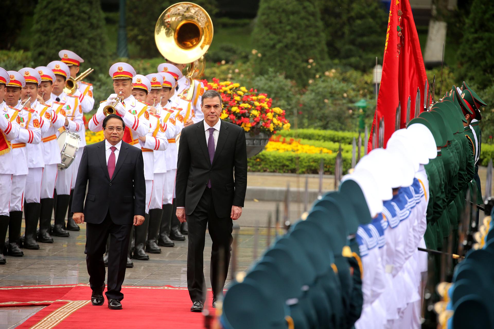 El primer ministro vietnamita, Pham Minh Chinh (centro-izq.) y su homólogo español, Pedro Sánchez (centro-der.), revisan la guardia de honor en el Palacio Presidencial de Hanoi, Vietnam. EFE/EPA/LUONG THAI LINH