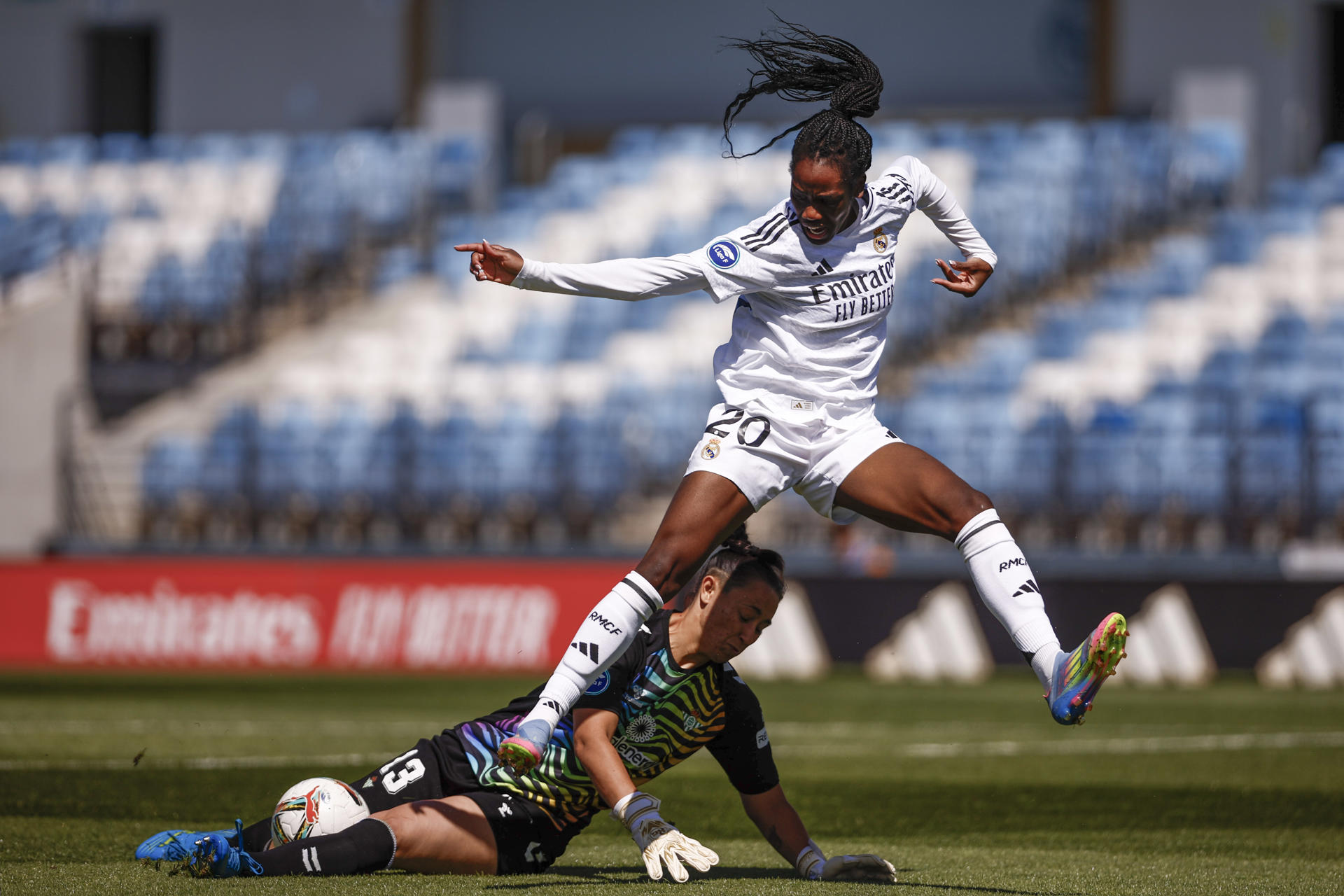 La centrocampista del Real Madrid Naomei Feller (d) y la portera del Betis, Paula Vizioso luchan por el balón durante el partido de Liga femenina que disputaron en el estadio Alfredo Di Stéfano de Madrid. EFE/ Daniel Gonzalez
