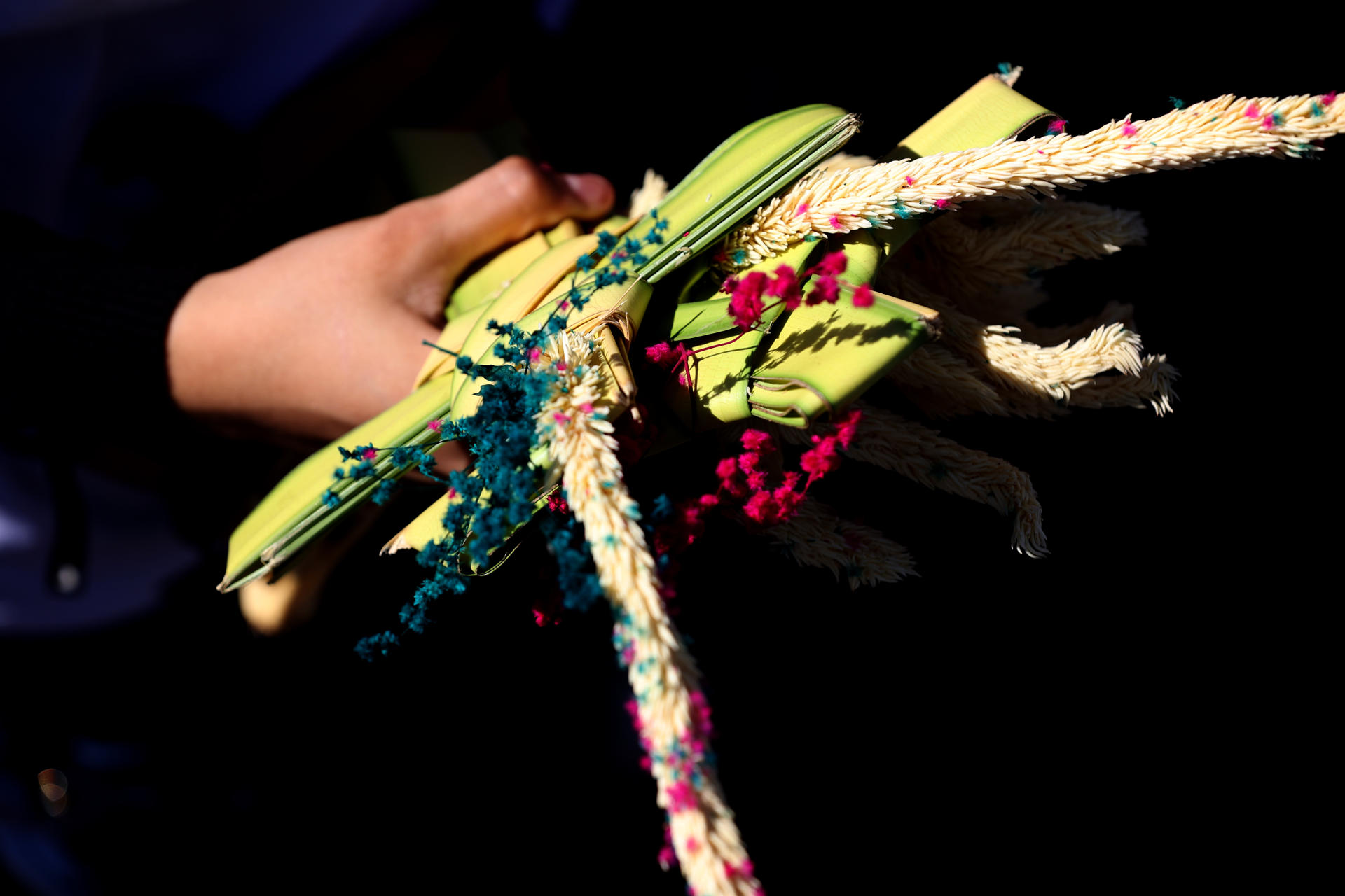 Una mujer sostiene una cruz de palma durante la misa del Domingo de Ramos, en el inicio de las festividades religiosas de Semana Santa este domingo en Managua (Nicaragua). EFE/STR