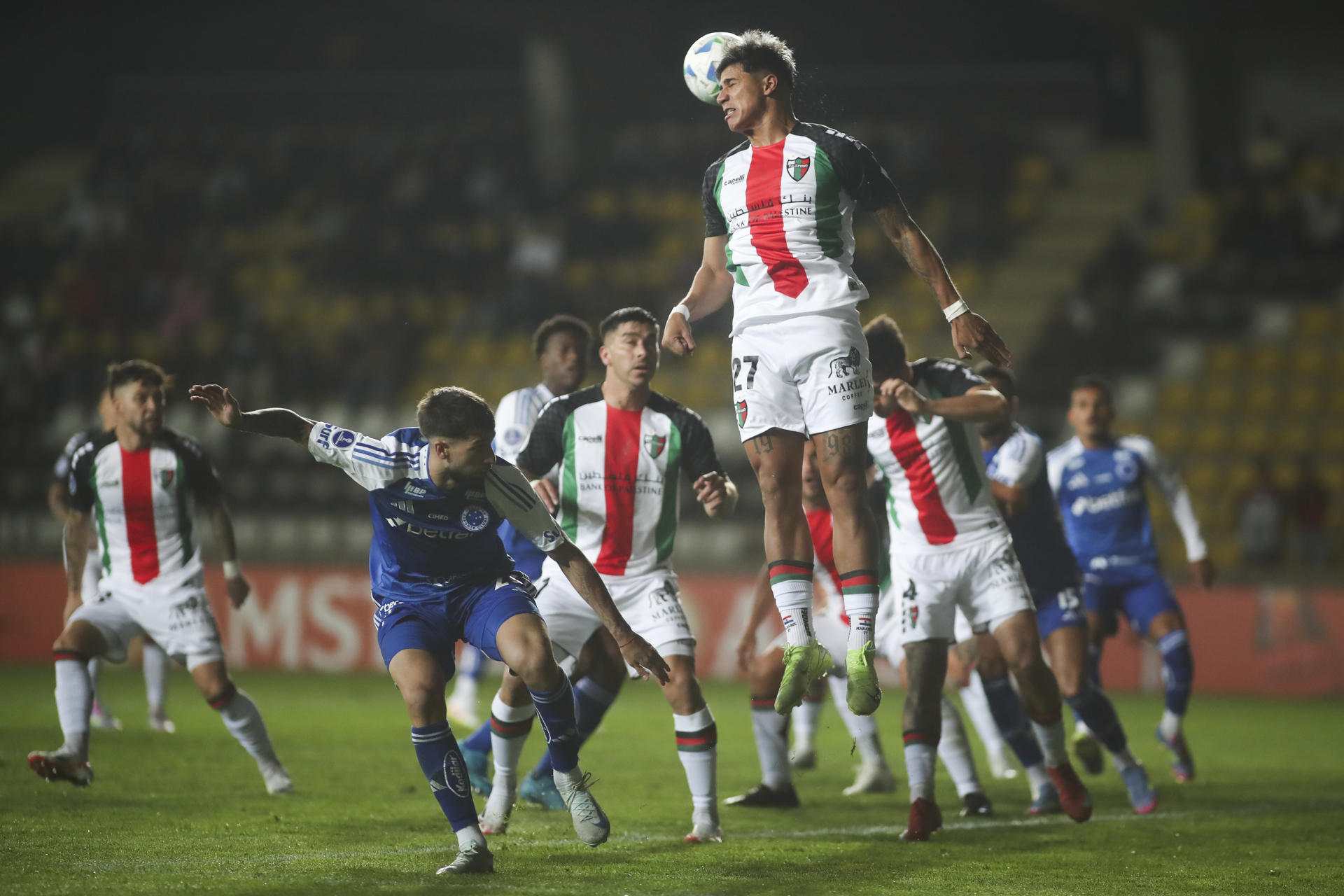 - Junior Marabel (arriba) de Palestino rechaza el balón a un partido de la fase de grupos de la Copa Sudamericana. EFE/ Hernán Contreras
