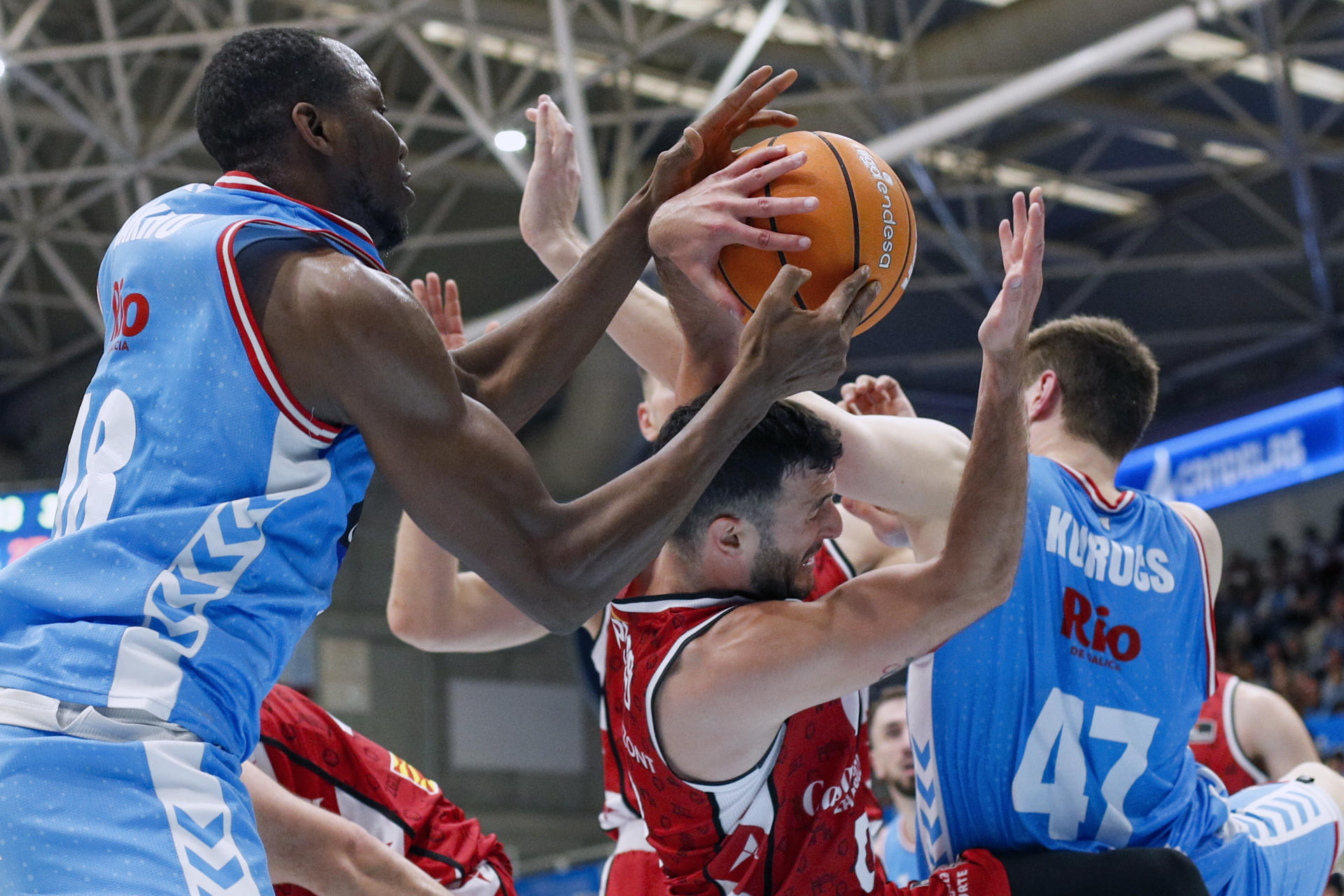 Los jugadores del Río Breogán Jordaan Sakho (i) y Kurucs (d) bloquean la entrada de un jugador del Casademont Zaragoza durante el partido de la Liga Endesa de baloncesto en el palacio de los Deportes de Lugo este domingo. EFE/Eliseo Trigo