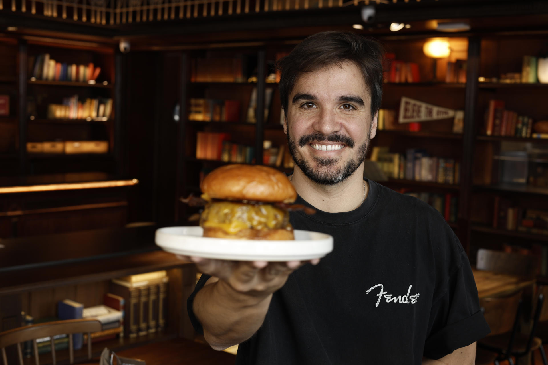 El cofundador de Hundred Burguers, Álex Gonzalez, posa con la hamburguesa "Singular" de Hundred que se ha alzado como la Mejor Hamburguesa del Mundo por segundo año consecutivo por The World´s Best Burgers, la Guía Michelín de las hamburguesas. EFE/Biel Aliño