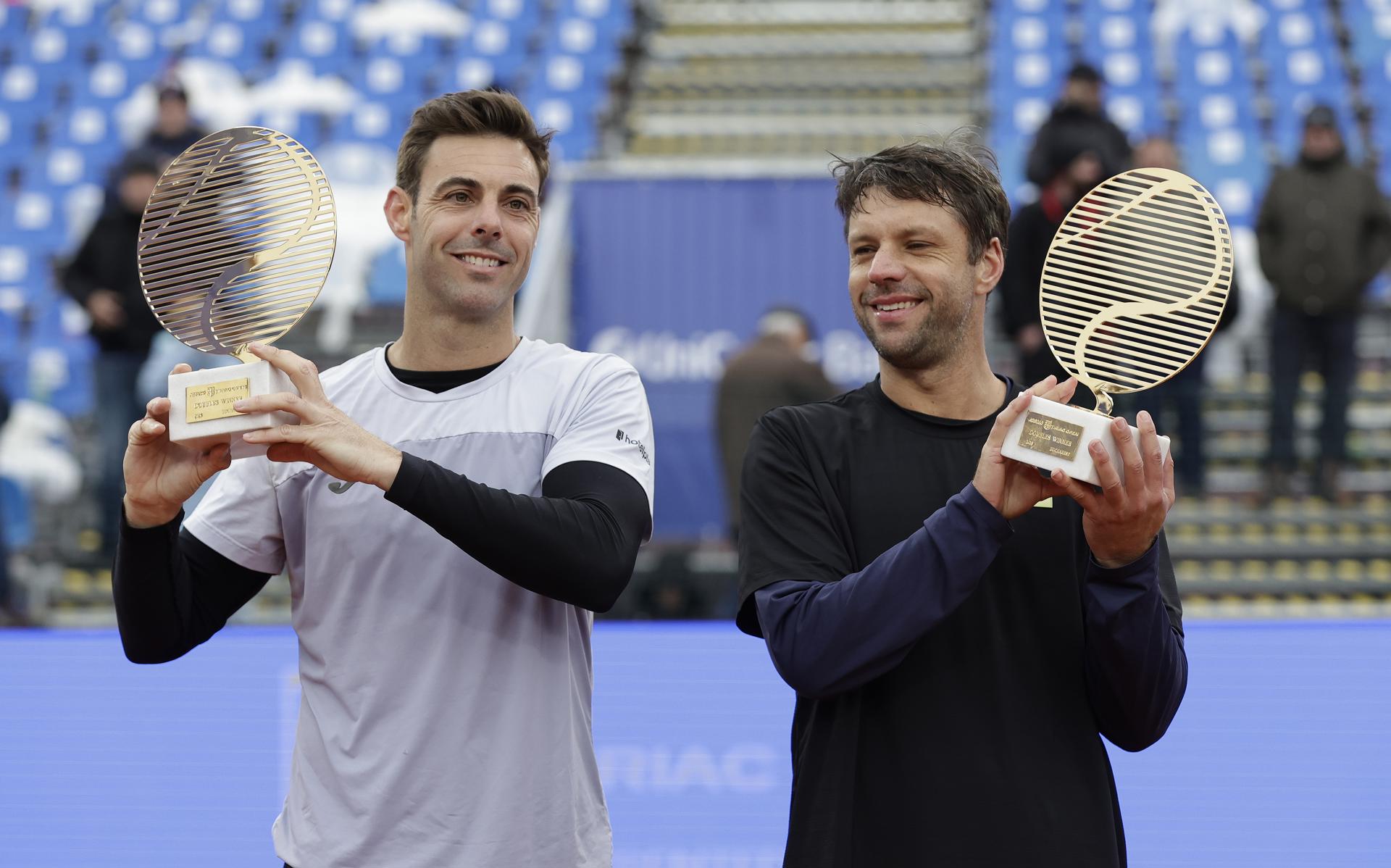 Los tenistas, el español Marcel Granollers y el argentino Horacio Zeballos, celebran trofeo en mano la consecución del título de dobles de la ATP en Bucarest, Rumania. EFE/EPA/Robert Ghement