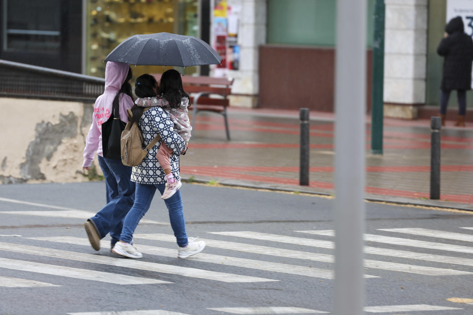 El tiempo inestable protagonizará la Semana Santa. n la imagen una familia camina bajo la lluvia en Toledo.. EFE/Ismael Herrero