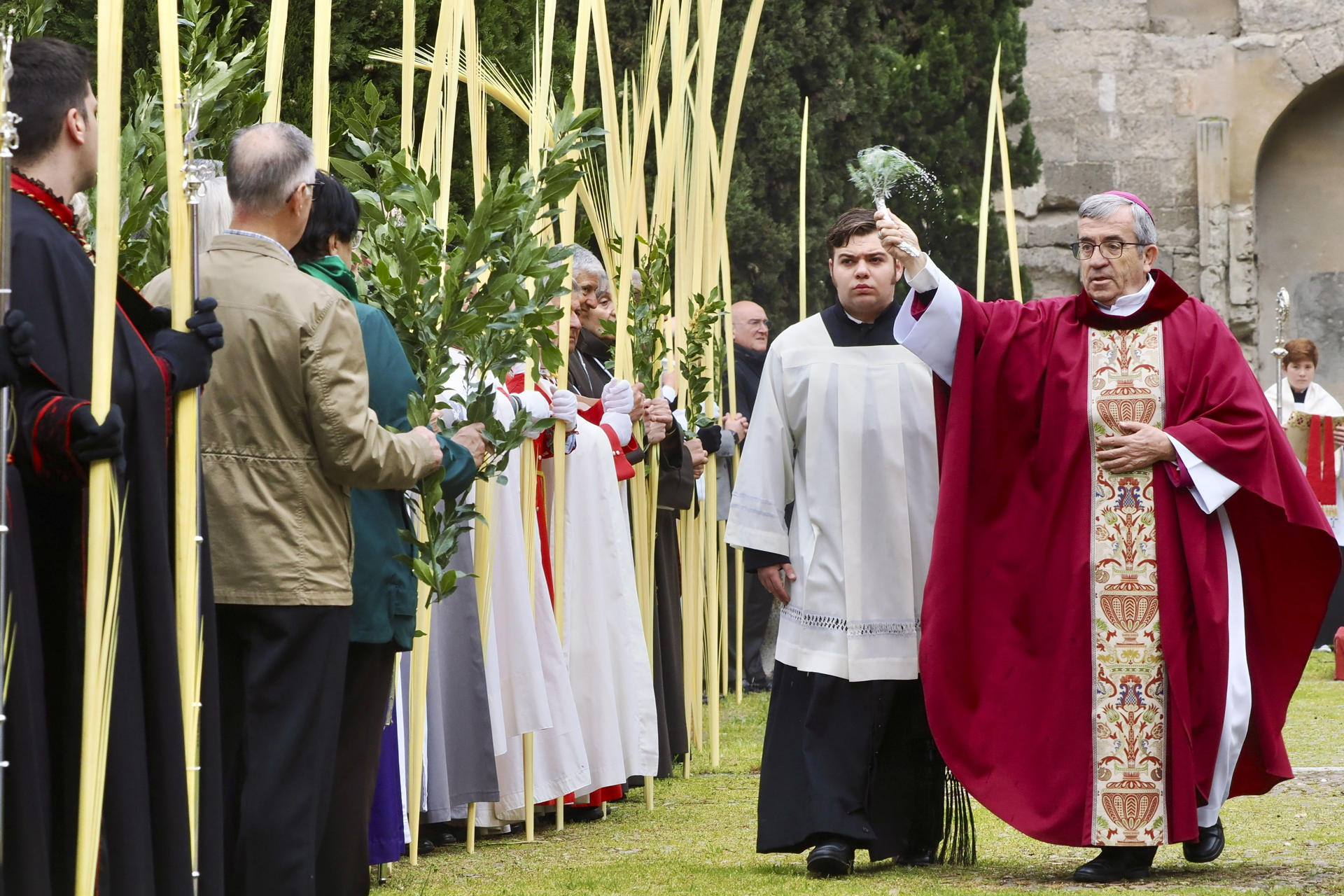 El arzobispo de Valladolid y presidente de la Conferencia Episcopal, Luis Argüello (i), bendice las palmas de los niños de las veinte cofradías de la ciudad, protagonistas de la procesión más alegre y multitudinaria de la Semana Santa, conocida como 'la borriquilla' EFE/ R. García