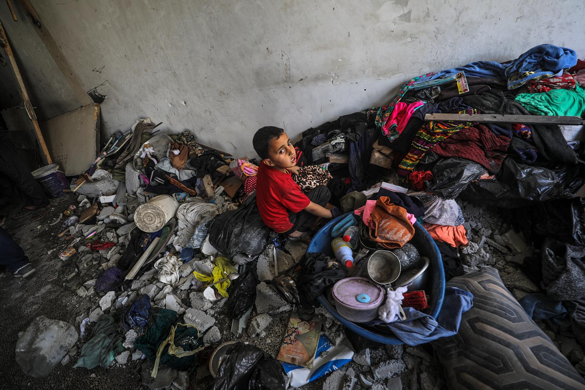 Un niño palestino desplazado interno se sienta entre escombros y sus pertenencias en el sitio de una clínica de la ONU tras un ataque aéreo israelí, en el campo de refugiados de Jabalia, en el norte de la Franja de Gaza, 02 de abril de 2025. 
EFE/EPA/MOHAMMED SABER
