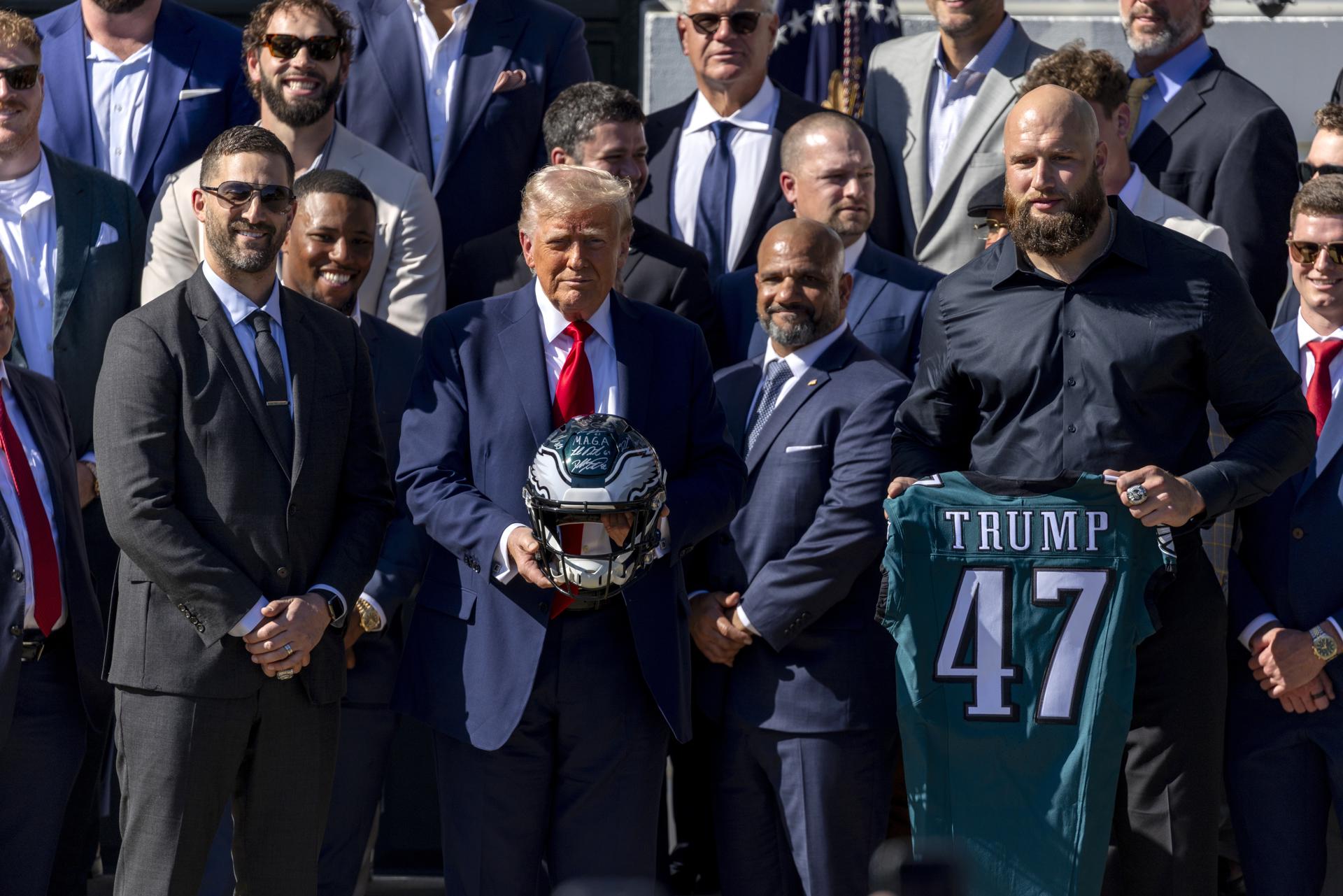 El presidente de EE.UU., Donald Trump, recibe souvenirs del head coach de los Philadelphia Eagles, Nick Sirianni (i), y del liniero ofensivo Lane Johnson (d) durante una visita con el campeón del Super Bowl 2025, los Philadelphia Eagles, en el jardín sur de la Casa Blanca en Washington, DC (EE.UU.). EFE/SHAWN THEW