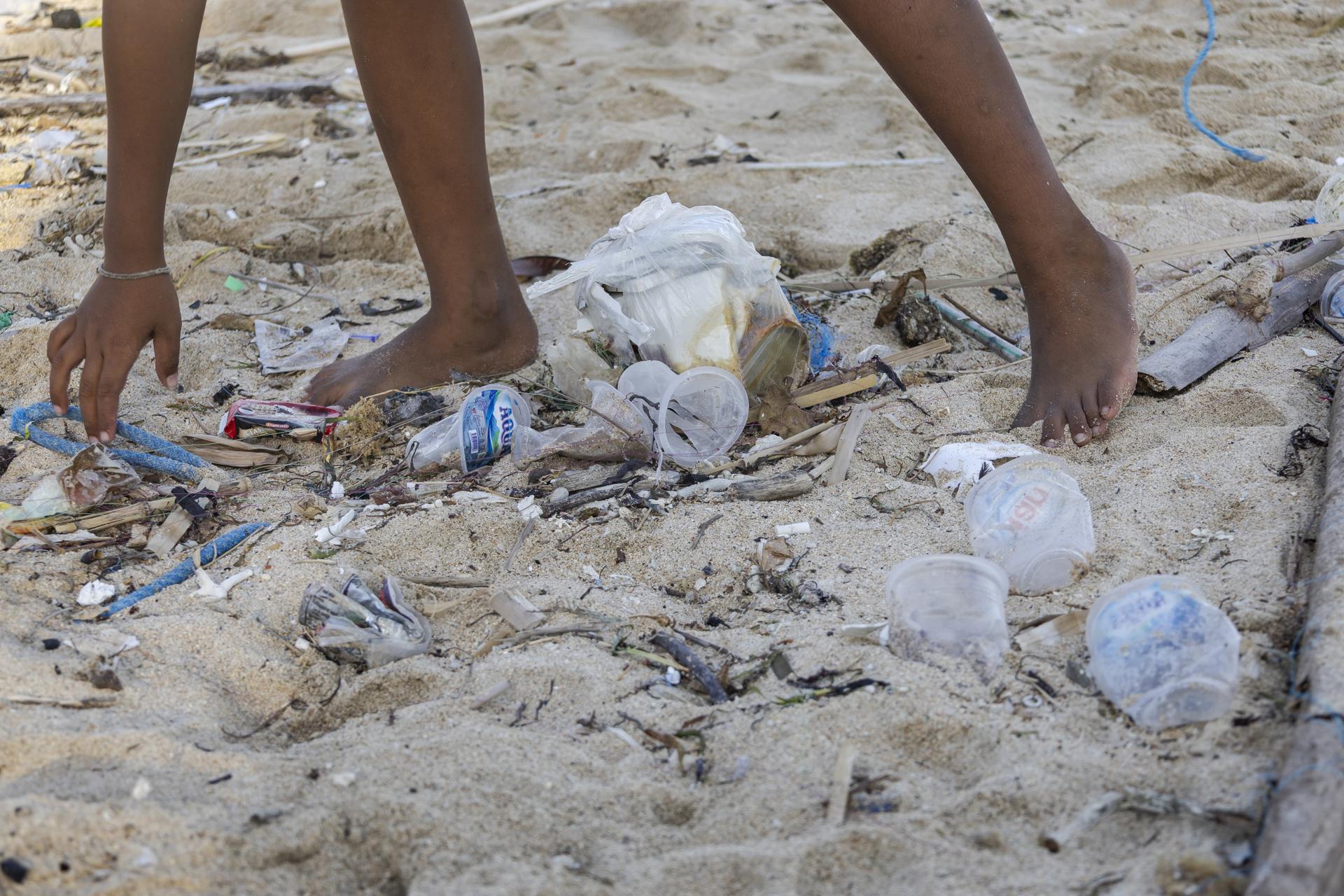 DENPASAR (Indonesia), 29/04/2025.- Una persona recoge escombros y residuos plásticos en una playa de Bali, Indonesia. EFE/EPA/MADE NAGI